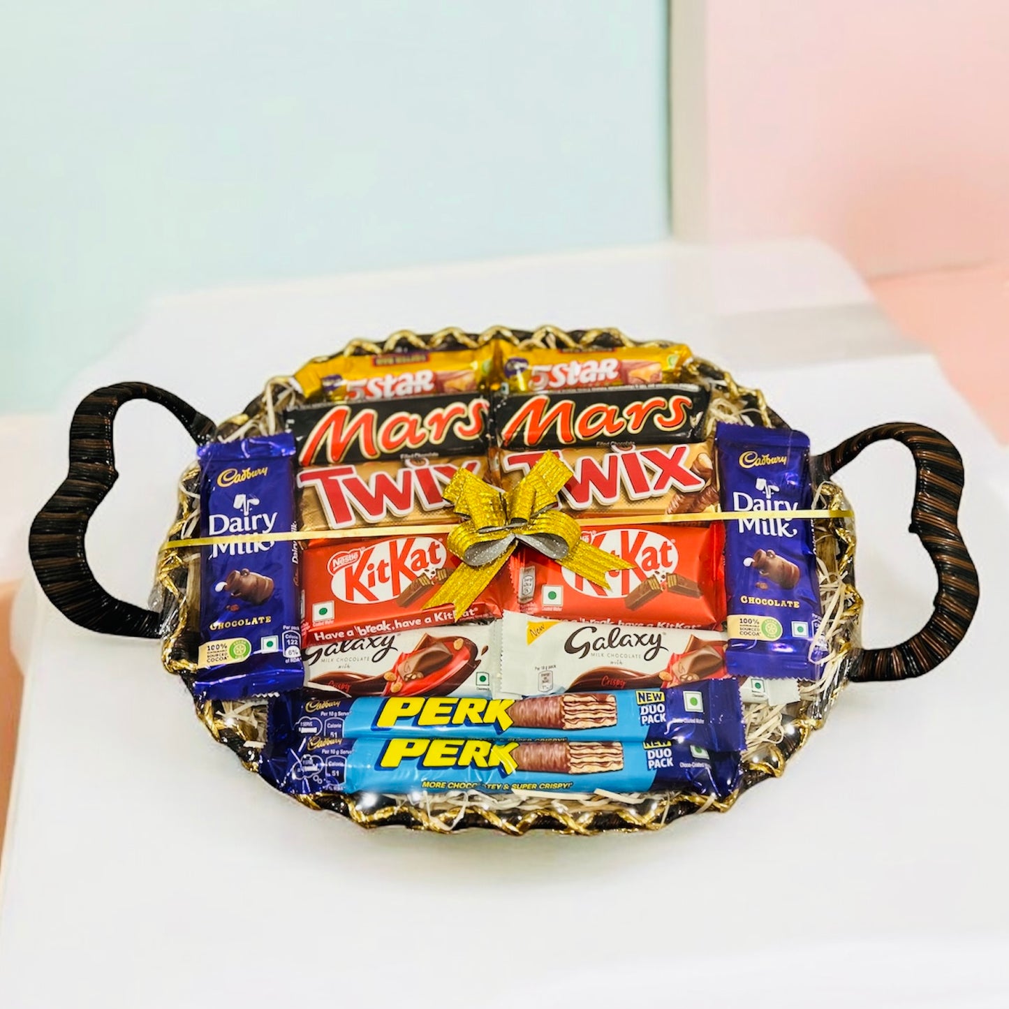 Assorted chocolate gift basket featuring Twix, Mars, Kit Kat, Galaxy, Perk, Dairy Milk, and 5 Star chocolates in a decorative basket.