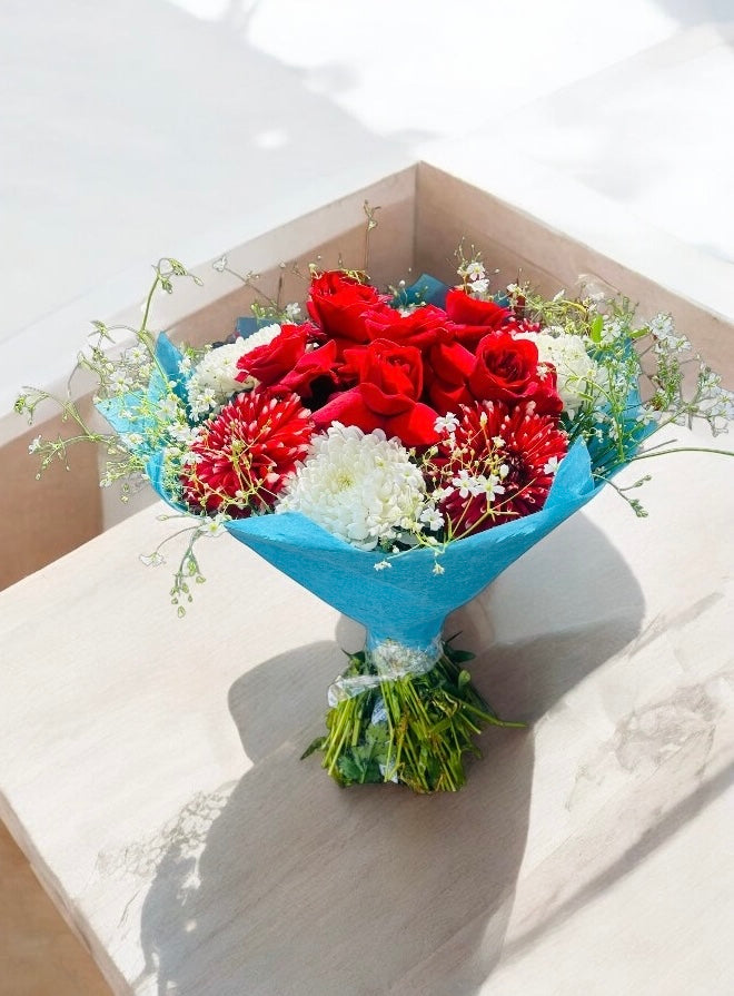 Elegant red rose and white chrysanthemum bouquet wrapped in blue paper – perfect for gifting on Valentine’s Day, anniversaries, and other celebrations.