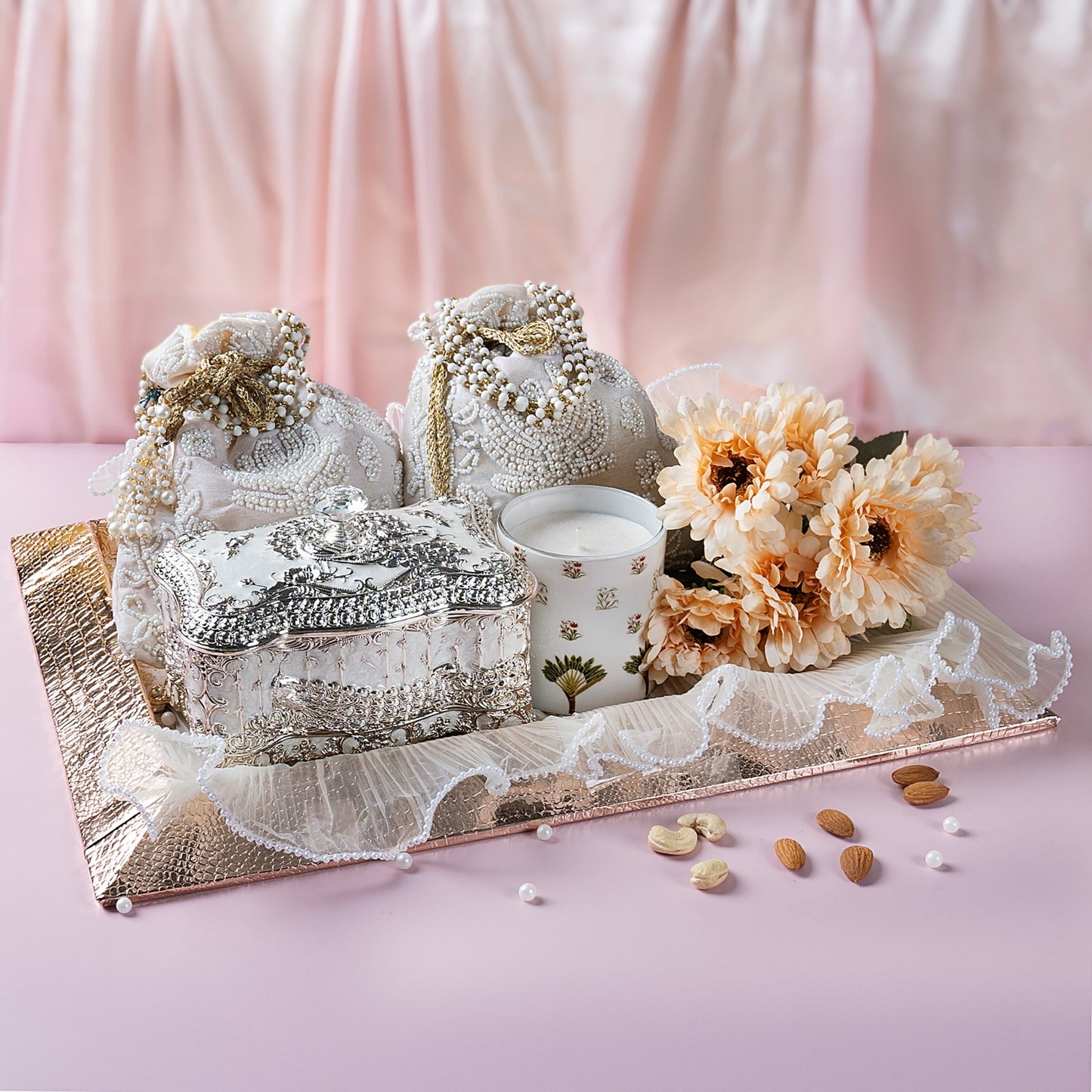 Luxury gift hamper with German Silver cookie box, beaded potli with dry fruits, scented candle in metal jar, and crocodile leather tray.