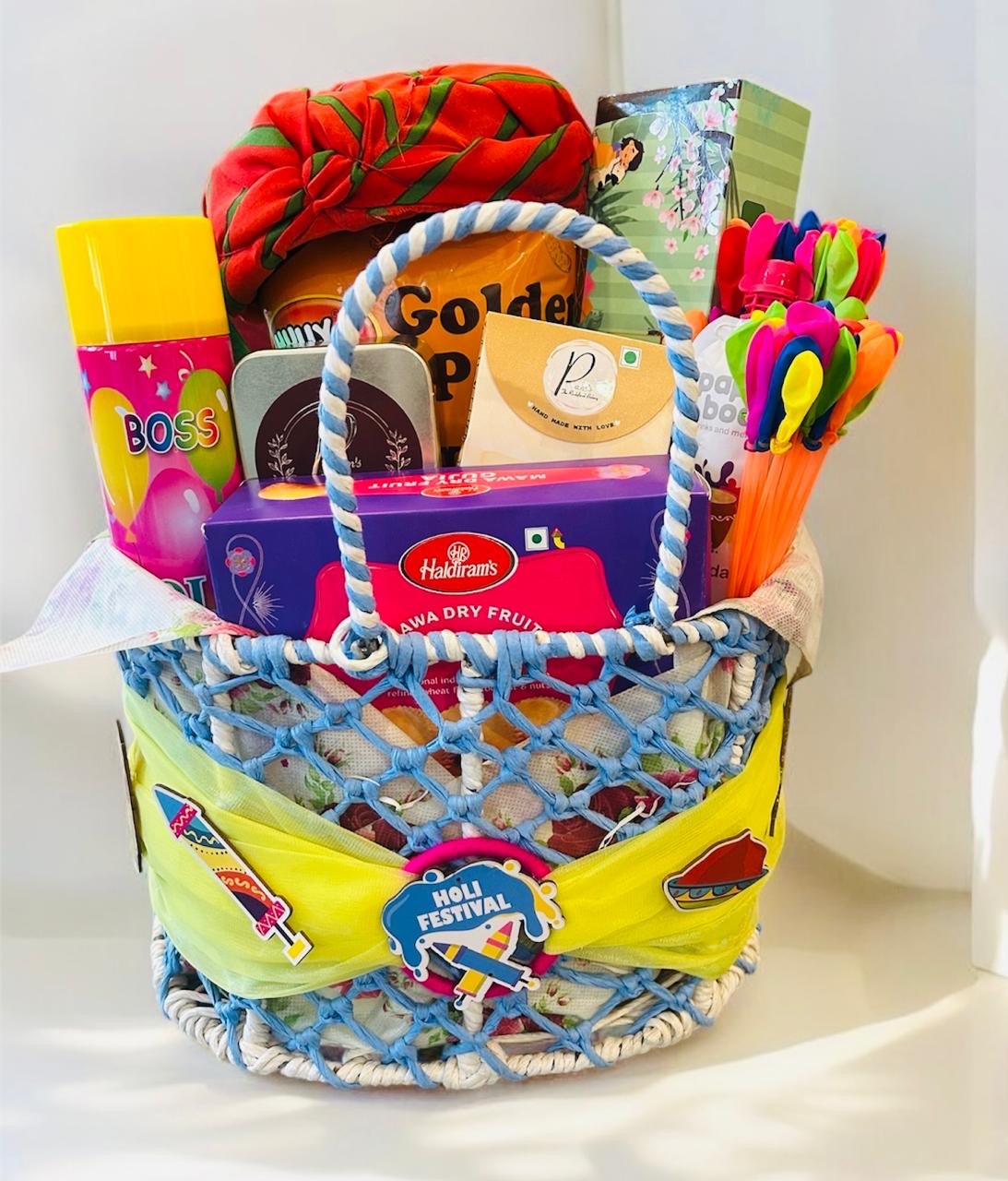 Holi gift hamper with organic gulal, thandai, Gujiya, cookies, chocolates, and snow spray in a decorative rafia basket