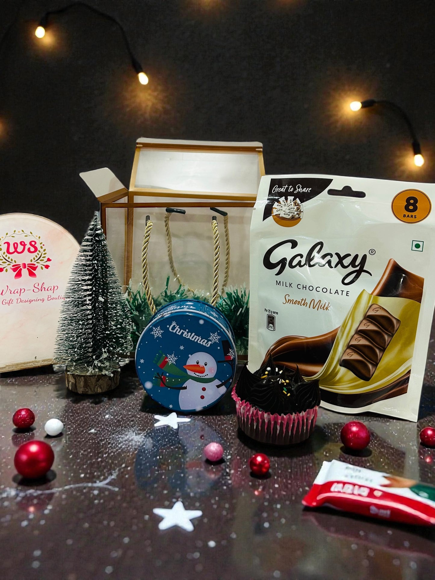 Compact Christmas gift hamper featuring festive cupcake, décor tree and chocolate in PVC bag.