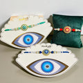 Evil Eye Rakhi (Design 2210) with blue nazar battu charm and thread work, includes Roli Chawal – by Wrap Shap