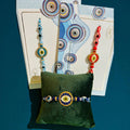 Evil Eye Rakhi with central metal charm and multiple blue evil eye beads on thread, roli chawal included – Wrap Shap