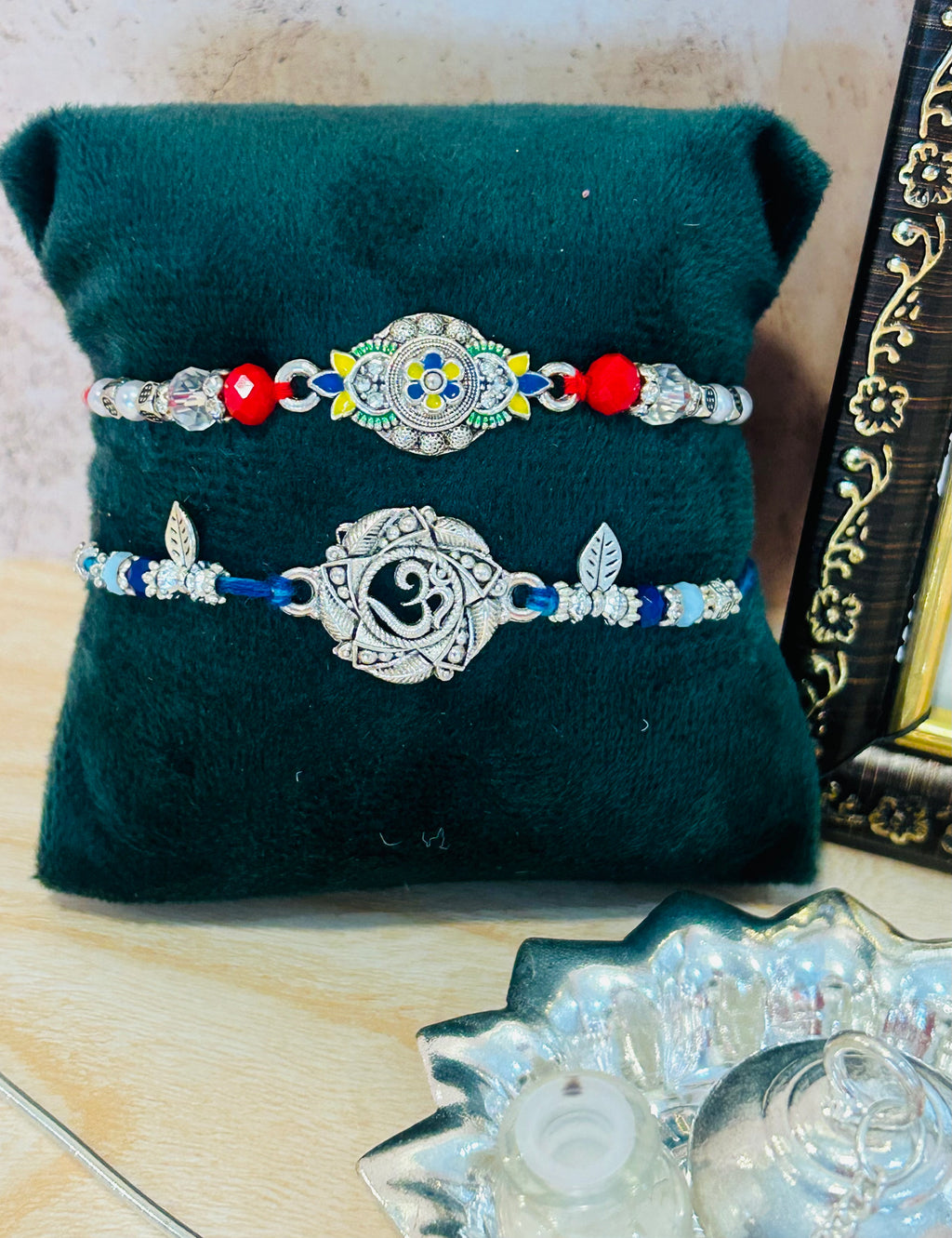 Set of 2 Rakhis – one with Om charm and one with colorful designer charm, with roli chawal pack – Wrap Shap Rakhi Collection