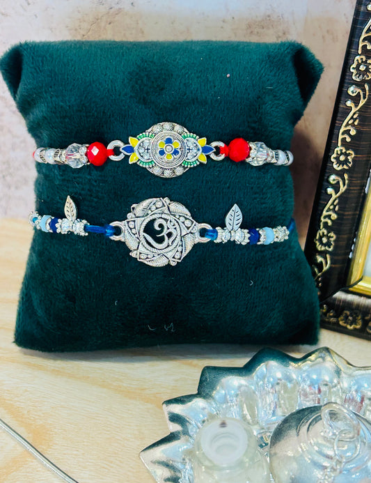 Set of 2 Rakhis – one with Om charm and one with colorful designer charm, with roli chawal pack – Wrap Shap Rakhi Collection