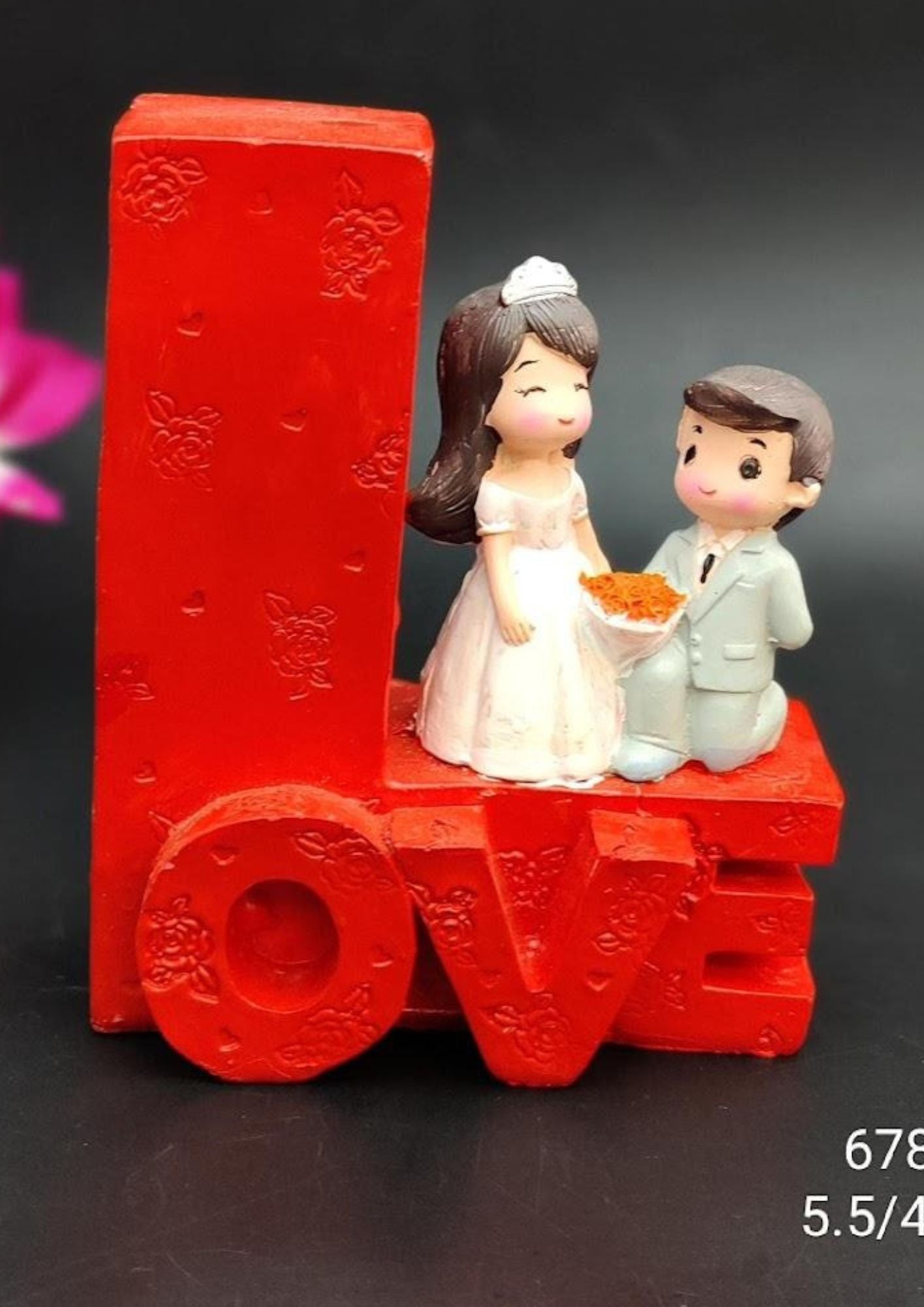 Romantic bride-and-groom figurine with a red LOVE base, featuring floral accents, ideal for Valentine’s Day, anniversary, birthday, and wedding gifts.