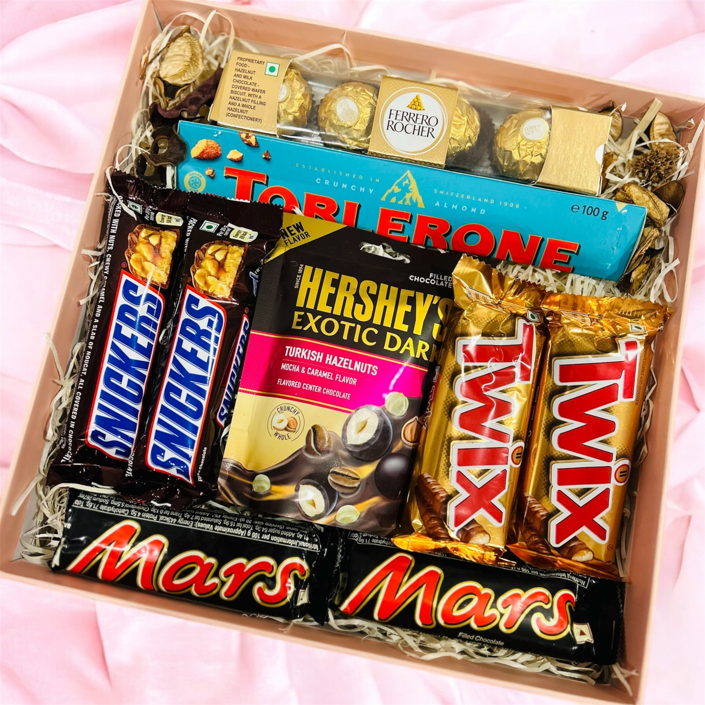Luxury assorted chocolate gift box with Ferrero Rocher, Toblerone, Snickers, Twix, Mars, and Hershey’s in an elegant gift packaging.