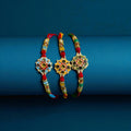Designer men’s rakhi with central star-shaped motif, multicolor stones, red and gold beadwork, and festive thread ends from Wrap Shap.