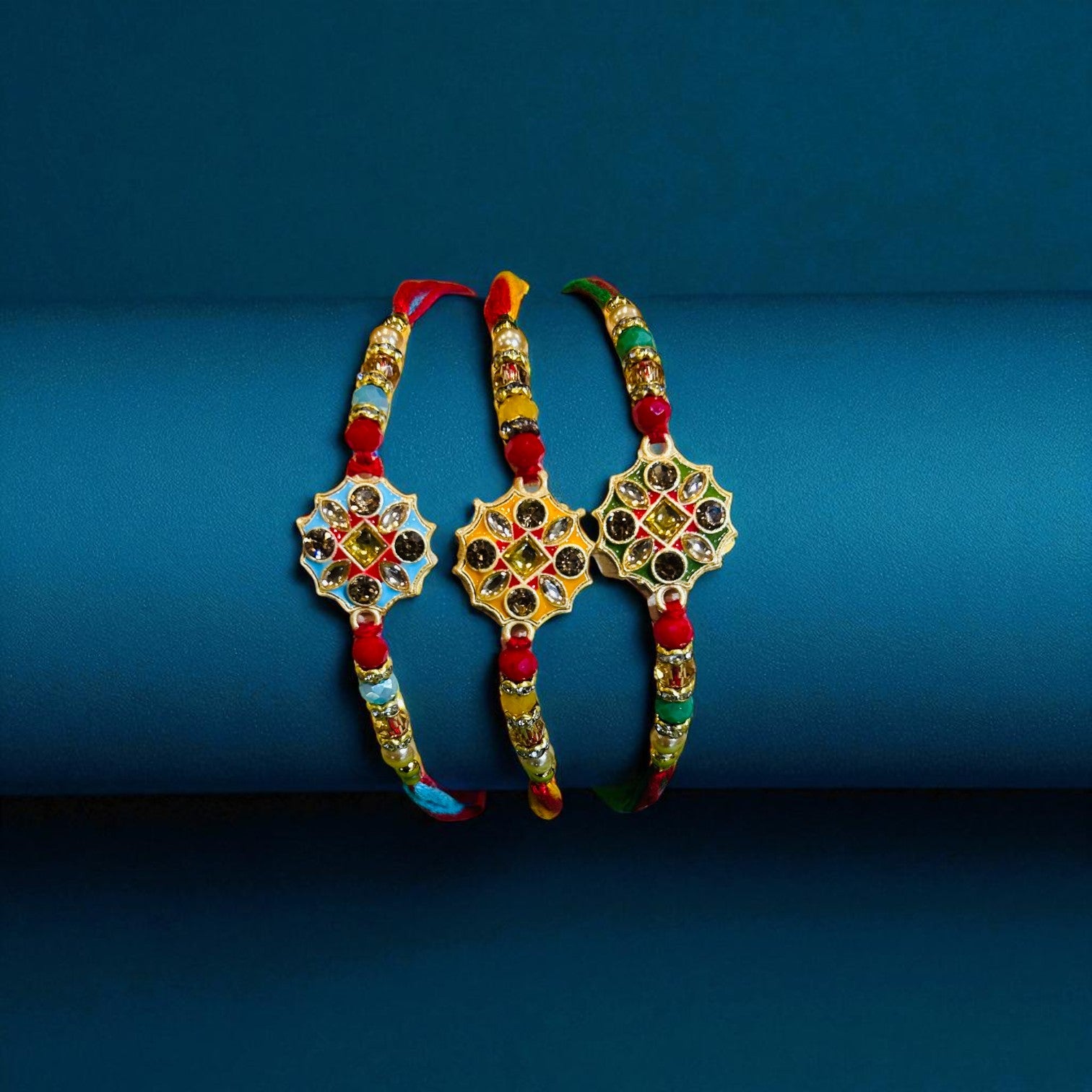 Designer men’s rakhi with central star-shaped motif, multicolor stones, red and gold beadwork, and festive thread ends from Wrap Shap.