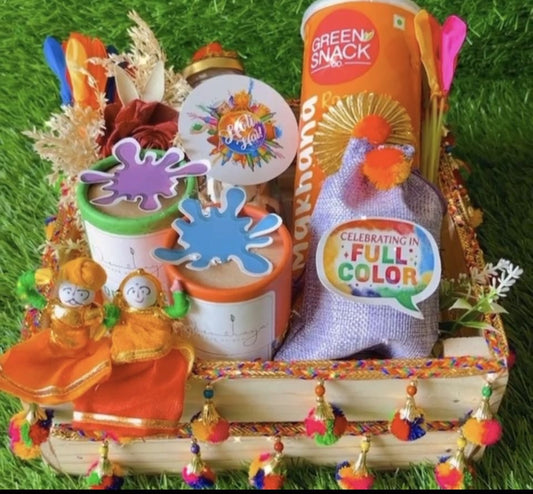 Holi Serenity Hamper: Nirmalaya Herbal Gulal, Makhana, Coated Dry Fruits, Water Balloons in Decorated Pinewood Basket