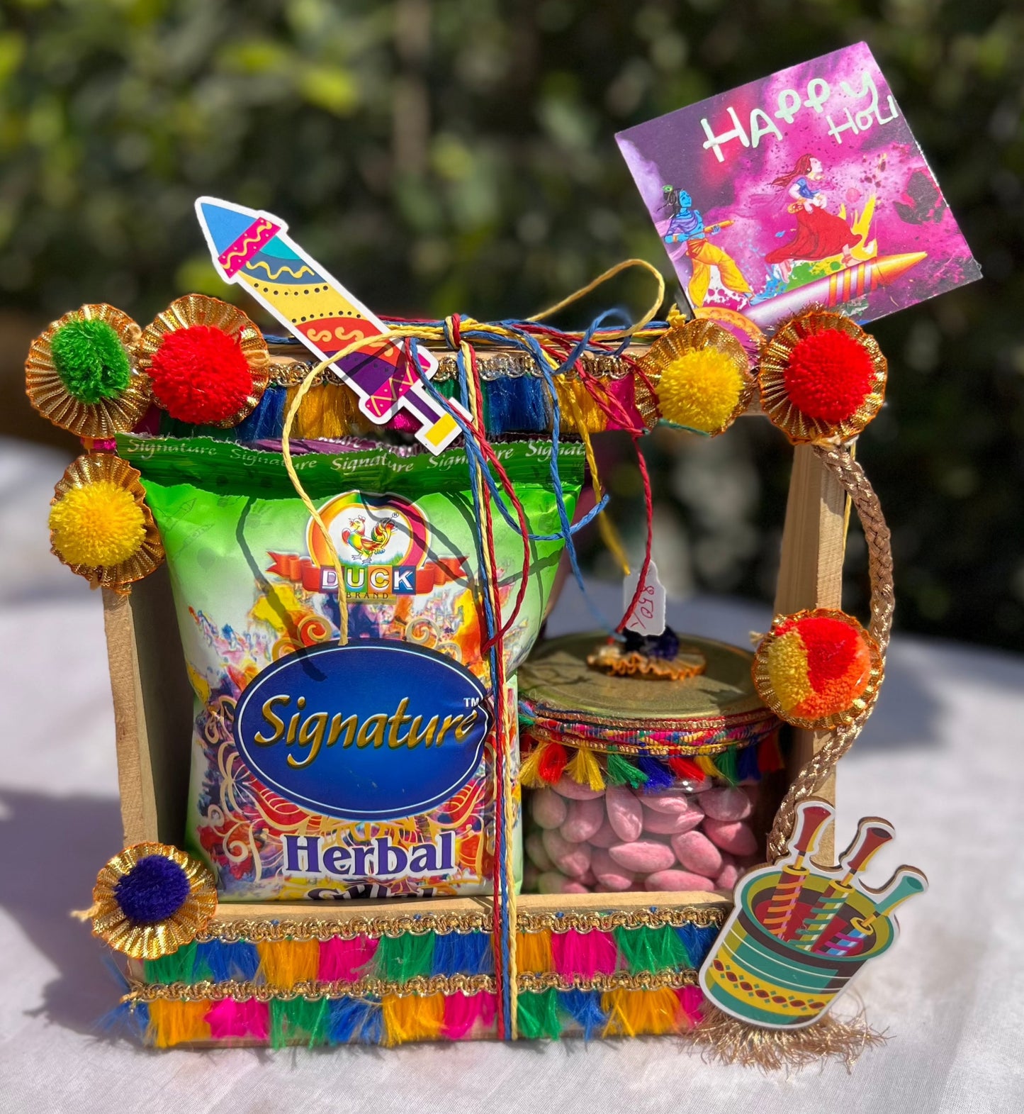 Joyful Hues Holi Hamper: Herbal Gulal and Coated Almonds in Decorated Pinewood Basket