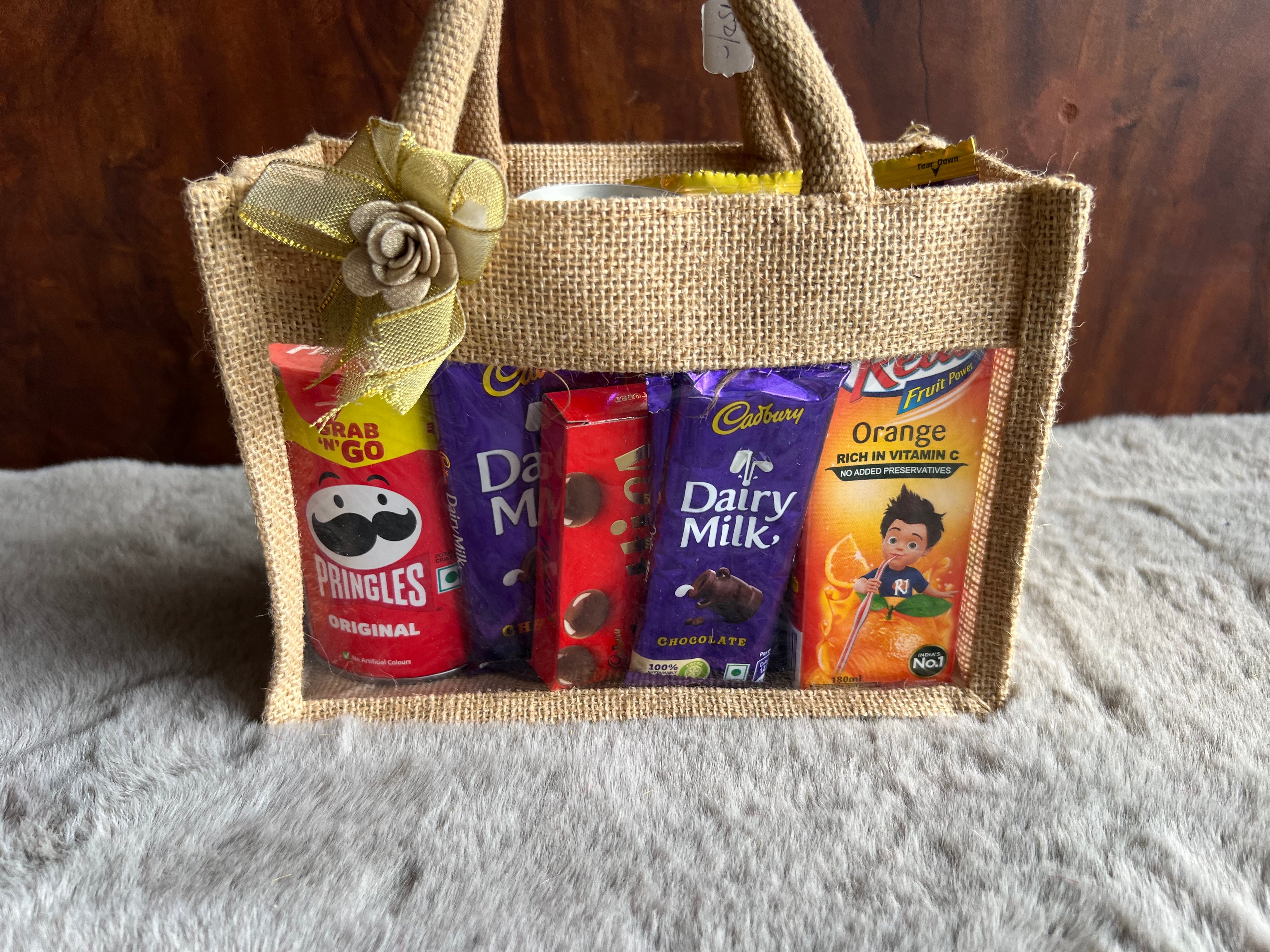 Snack Delight Rakhi Hamper with Pringles, Tong Garden Peanuts, Coke, Juice & Chocolates in Jute Gifting Bag