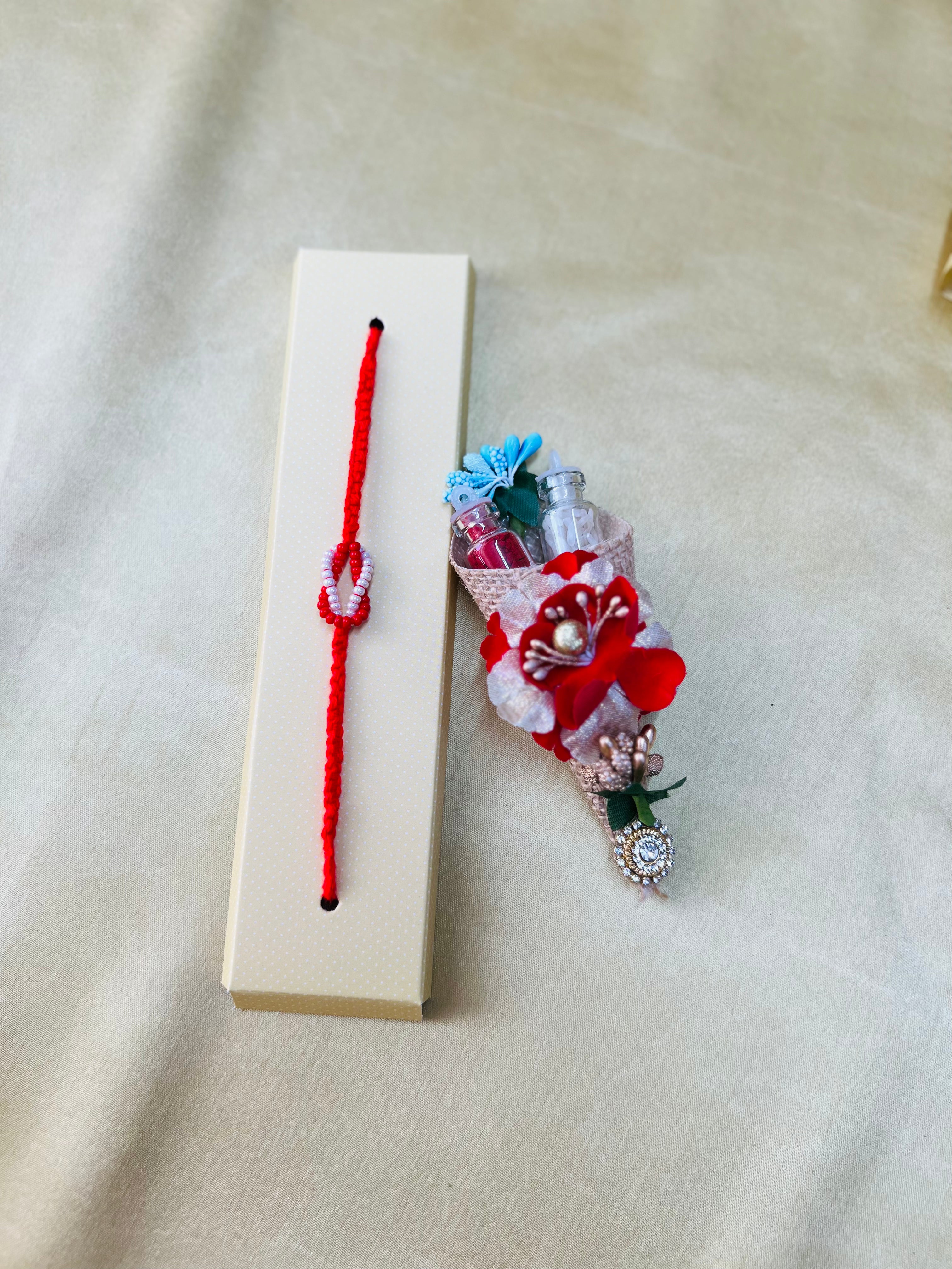 Wrap Shap RM801: Designer Beaded Rakhi with Red & White Infinity Symbol and Roli Chawal