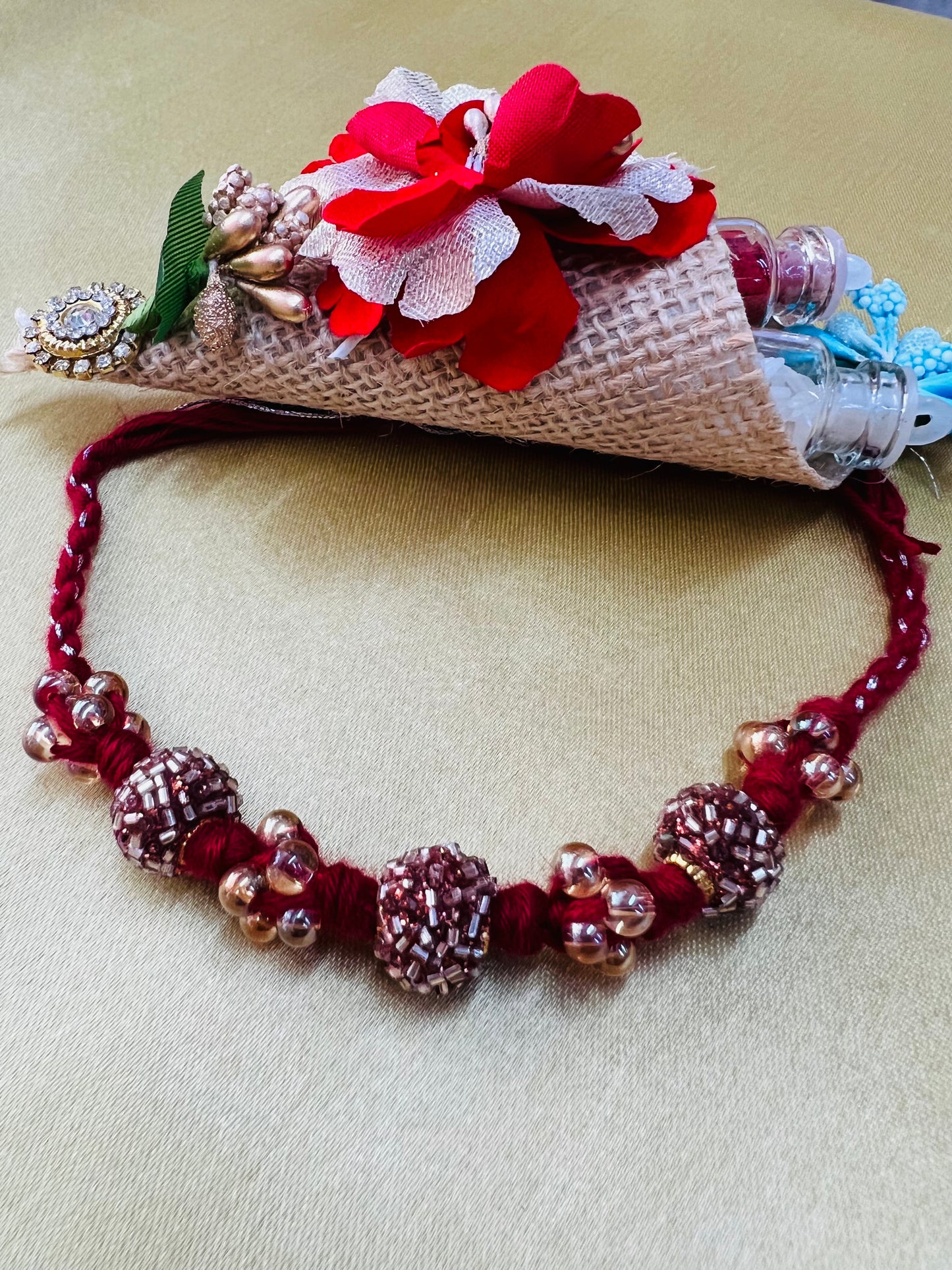 Wrap Shap RM811: Designer Crimson Beaded Rakhi with Decorative Elements and Roli Chawal