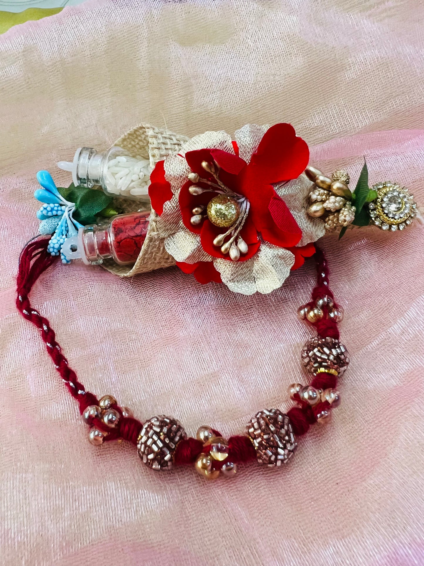 Wrap Shap RM811: Designer Crimson Beaded Rakhi with Decorative Elements and Roli Chawal