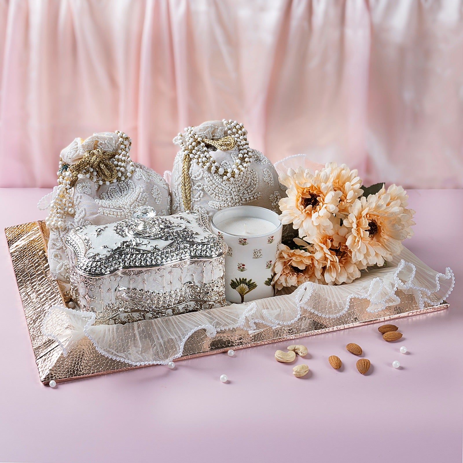 Luxury gift hamper with German Silver cookie box, beaded potli with dry fruits, scented candle in metal jar, and crocodile leather tray.