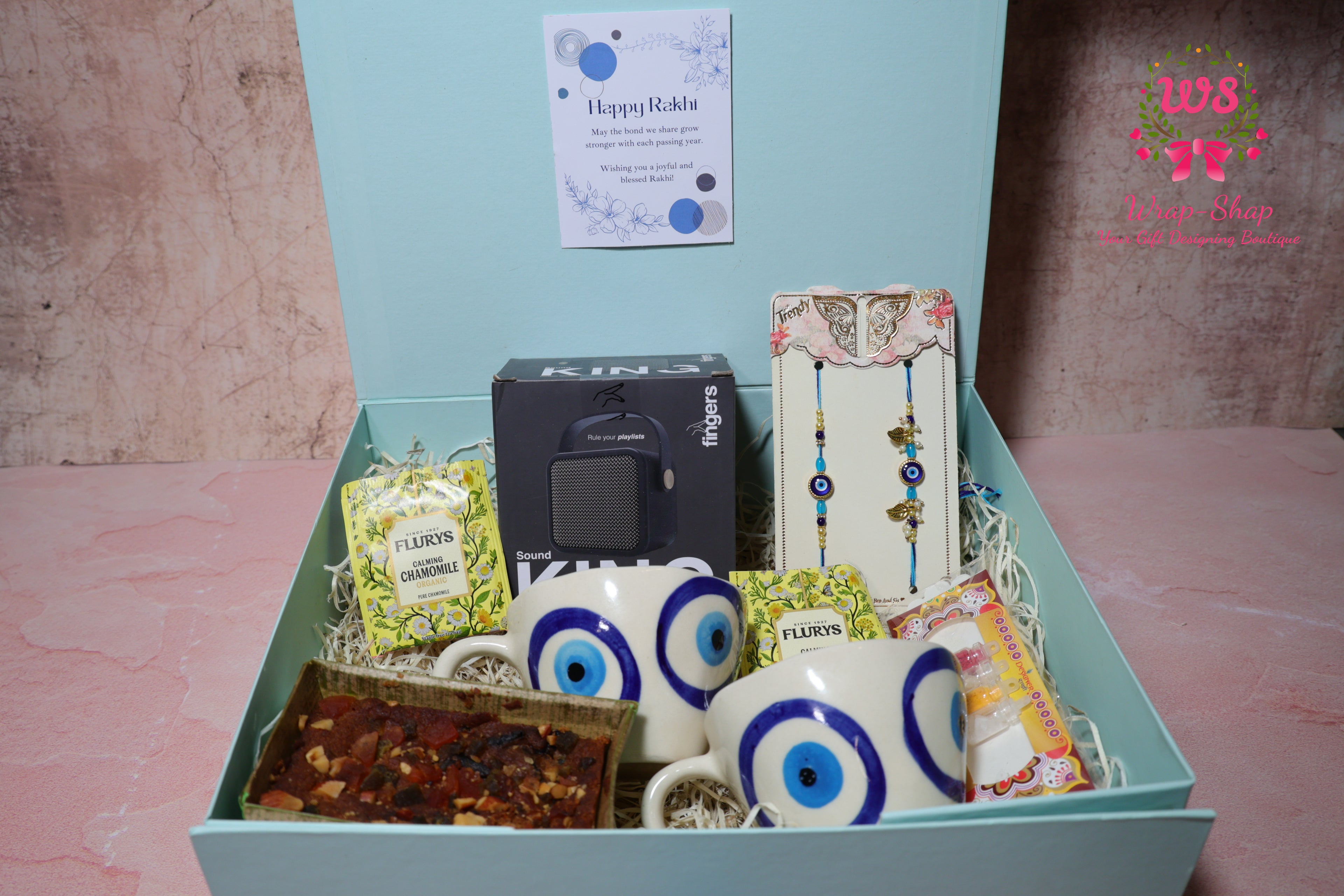 Bhaiya Bhabhi Rakhi Hamper with Evil Eye Tea Cups, Bluetooth Speaker, Tea Bags & Tea Cake in Gift Box | Wrap Shap