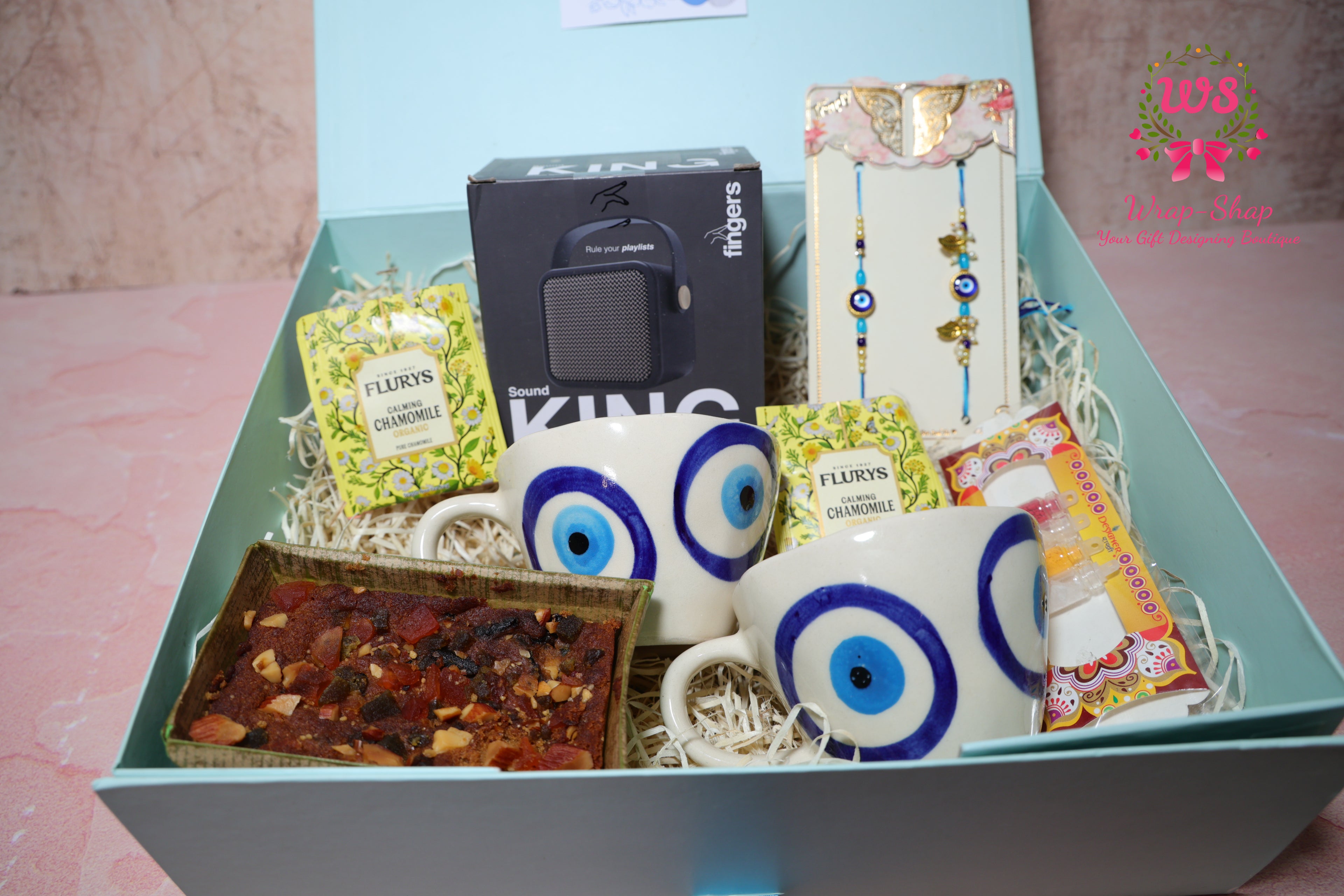 Bhaiya Bhabhi Rakhi Hamper with Evil Eye Tea Cups, Bluetooth Speaker, Tea Bags & Tea Cake in Gift Box | Wrap Shap