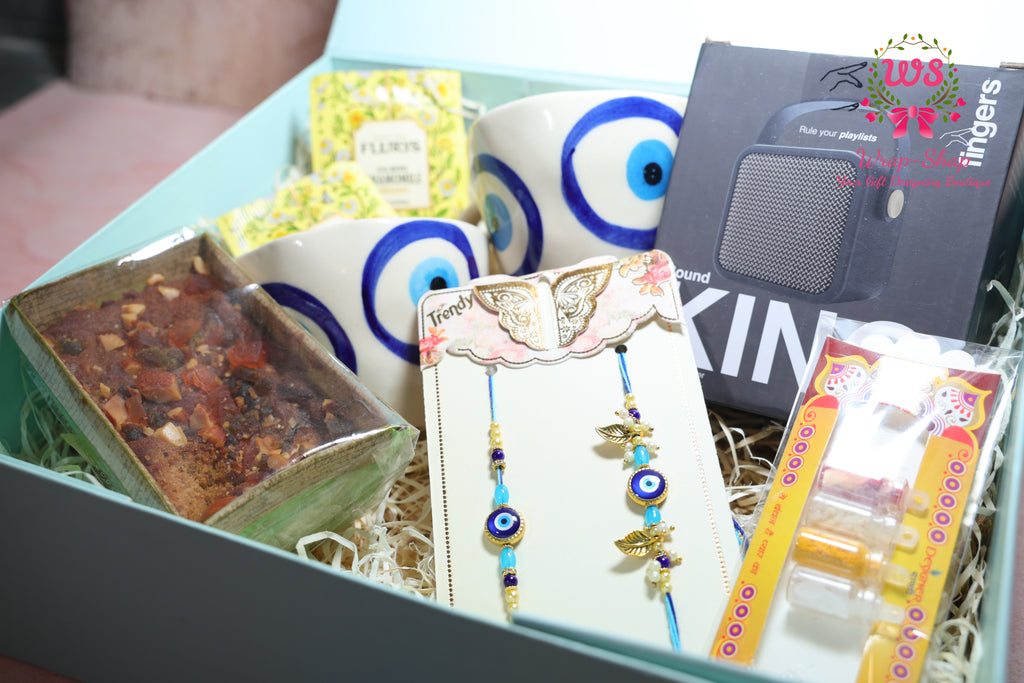 Bhaiya Bhabhi Rakhi Hamper with Evil Eye Tea Cups, Bluetooth Speaker, Tea Bags & Tea Cake in Gift Box | Wrap Shap