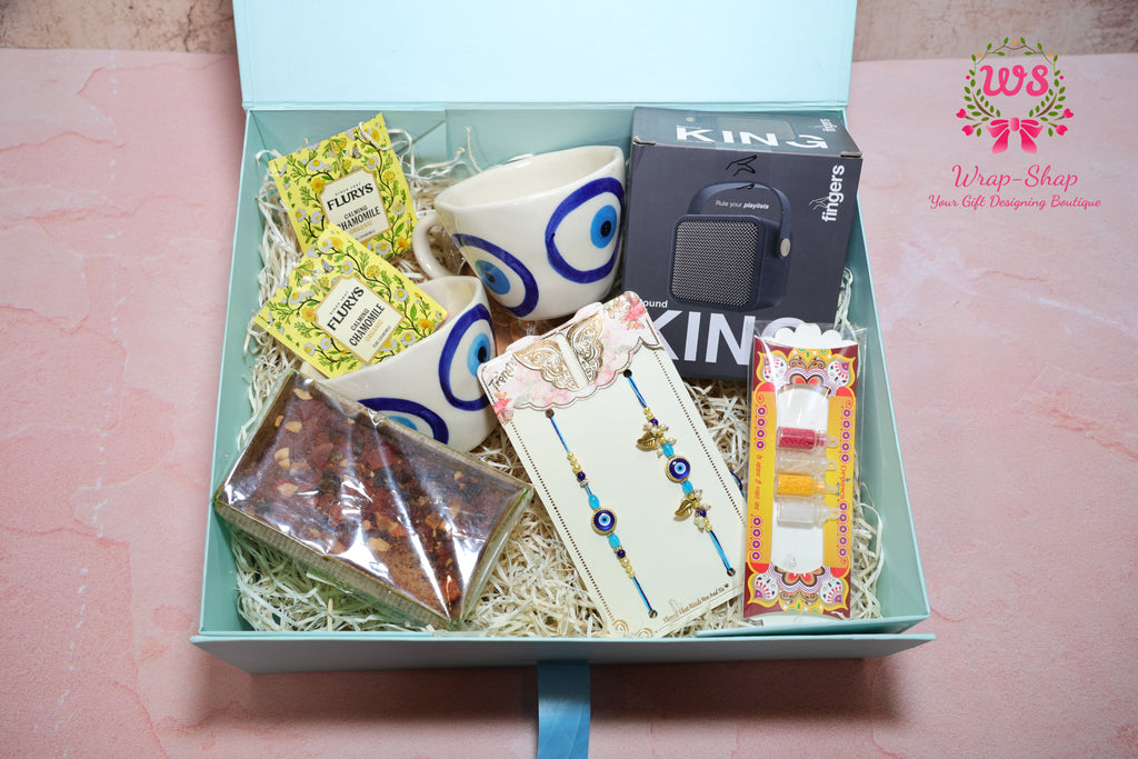 Bhaiya Bhabhi Rakhi Hamper with Evil Eye Tea Cups, Bluetooth Speaker, Tea Bags & Tea Cake in Gift Box | Wrap Shap