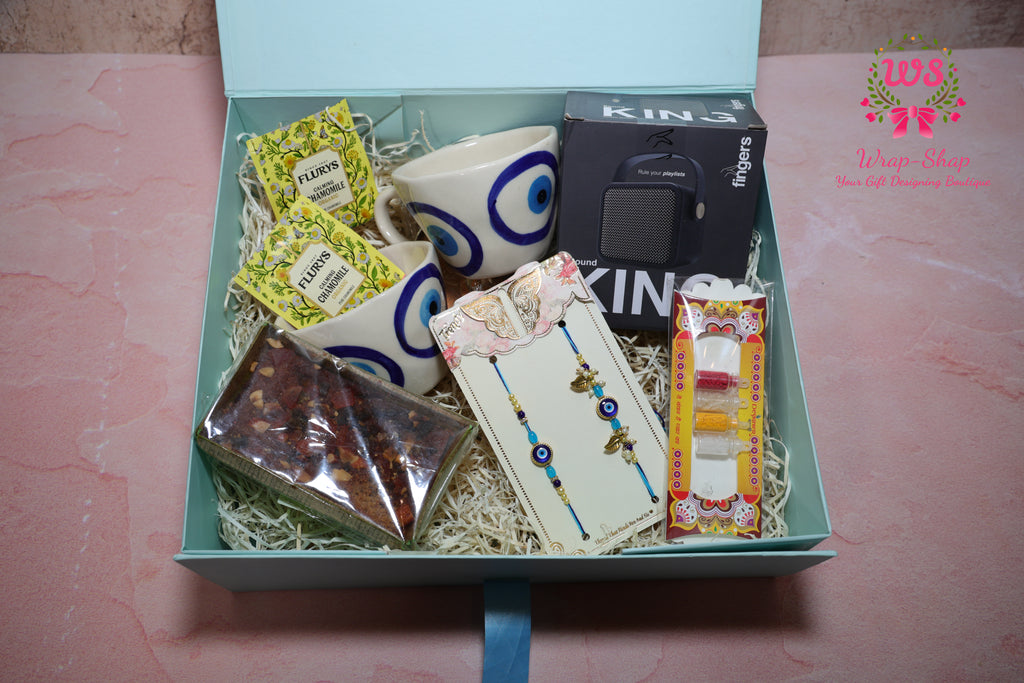 Bhaiya Bhabhi Rakhi Hamper with Evil Eye Tea Cups, Bluetooth Speaker, Tea Bags & Tea Cake in Gift Box | Wrap Shap