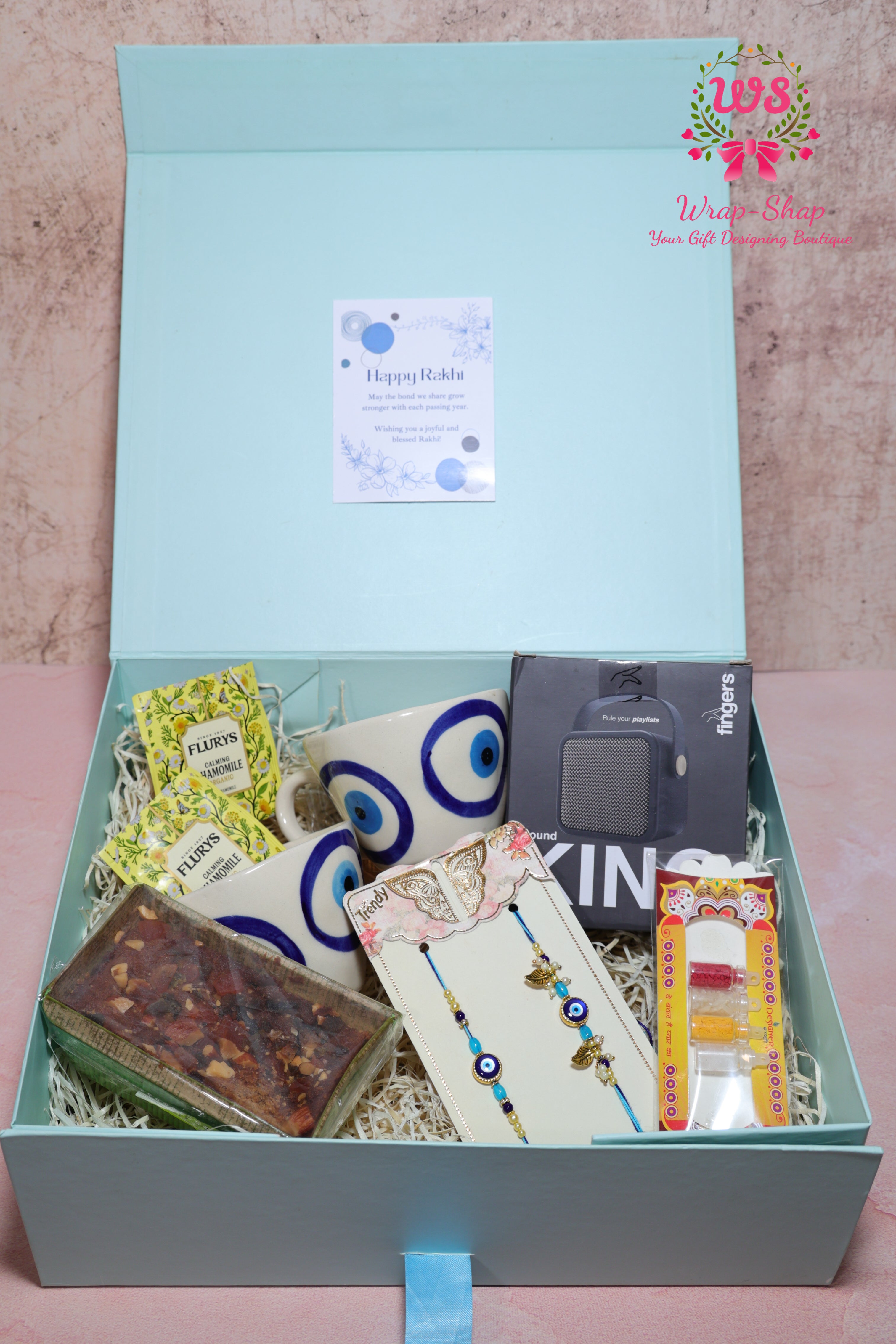 Bhaiya Bhabhi Rakhi Hamper with Evil Eye Tea Cups, Bluetooth Speaker, Tea Bags & Tea Cake in Gift Box | Wrap Shap