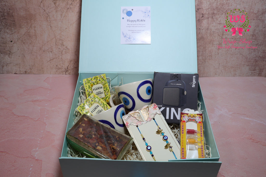 Bhaiya Bhabhi Rakhi Hamper with Evil Eye Tea Cups, Bluetooth Speaker, Tea Bags & Tea Cake in Gift Box | Wrap Shap