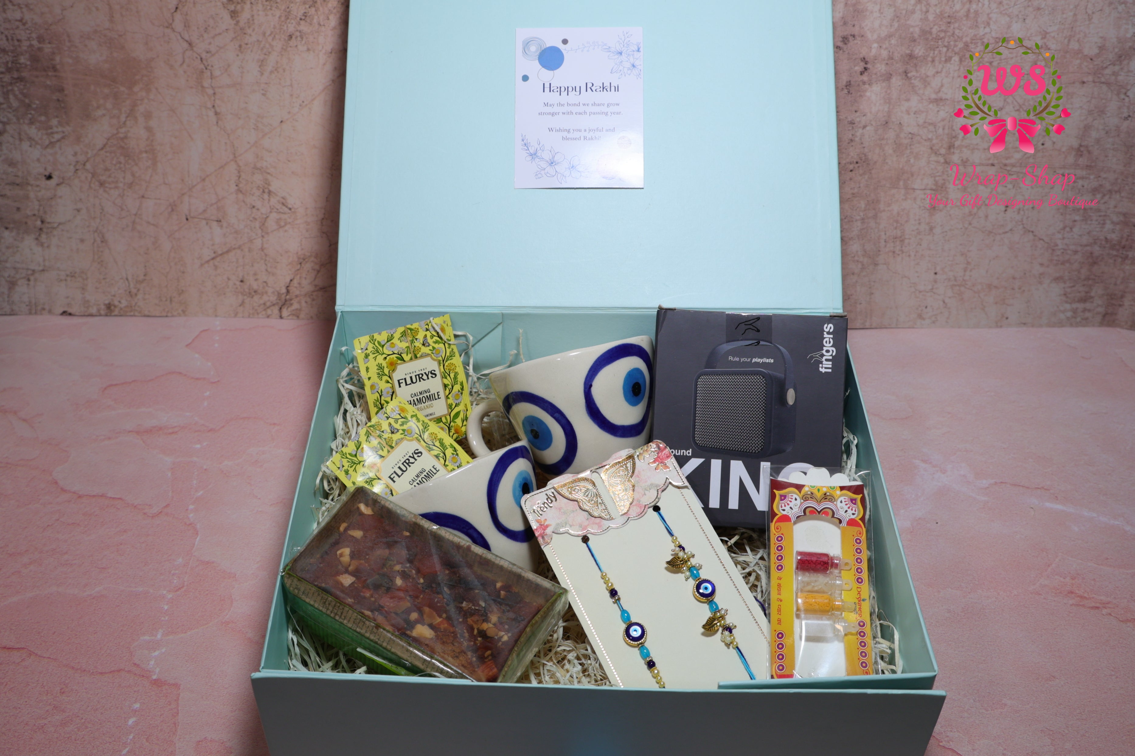 Bhaiya Bhabhi Rakhi Hamper with Evil Eye Tea Cups, Bluetooth Speaker, Tea Bags & Tea Cake in Gift Box | Wrap Shap