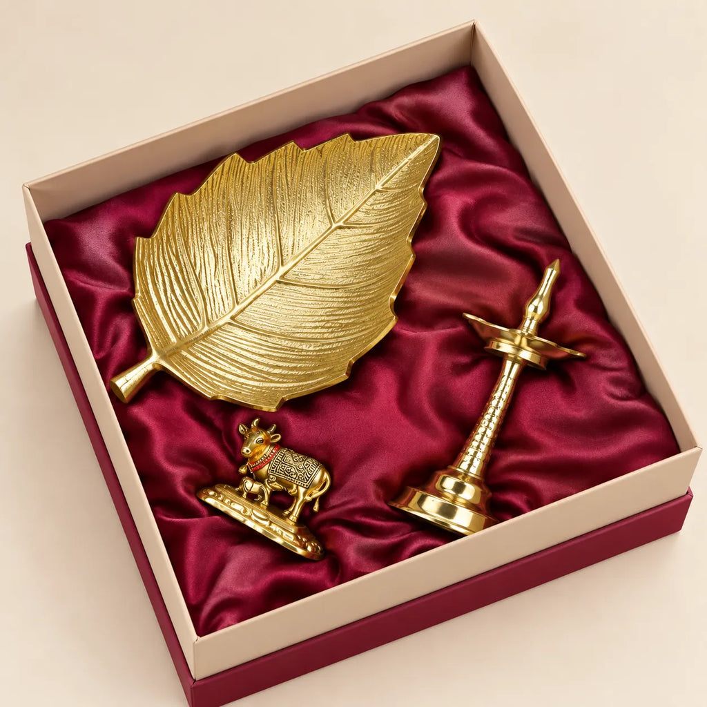 Taru leaf platter, golden brass Samai lamp and Kamdhenu cow with calf in a premium gift box by Wrap Shap