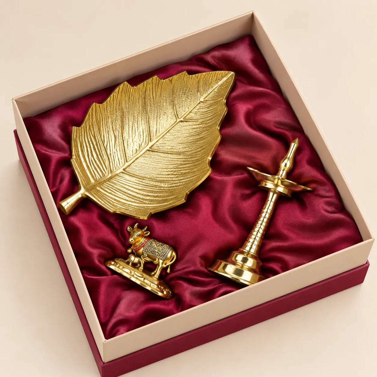 Taru leaf platter, golden brass Samai lamp and Kamdhenu cow with calf in a premium gift box by Wrap Shap
