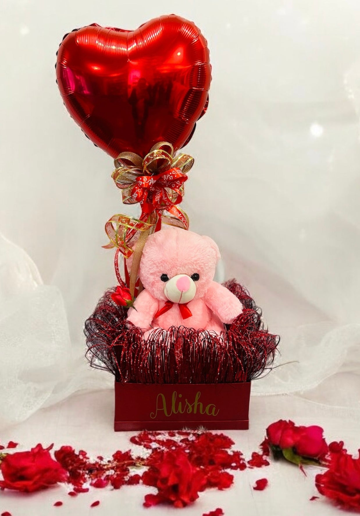 Teddy hamper featuring a plush teddy bear, heart-shaped balloon, and customized name gift box, ideal for romantic occasions and special celebrations.