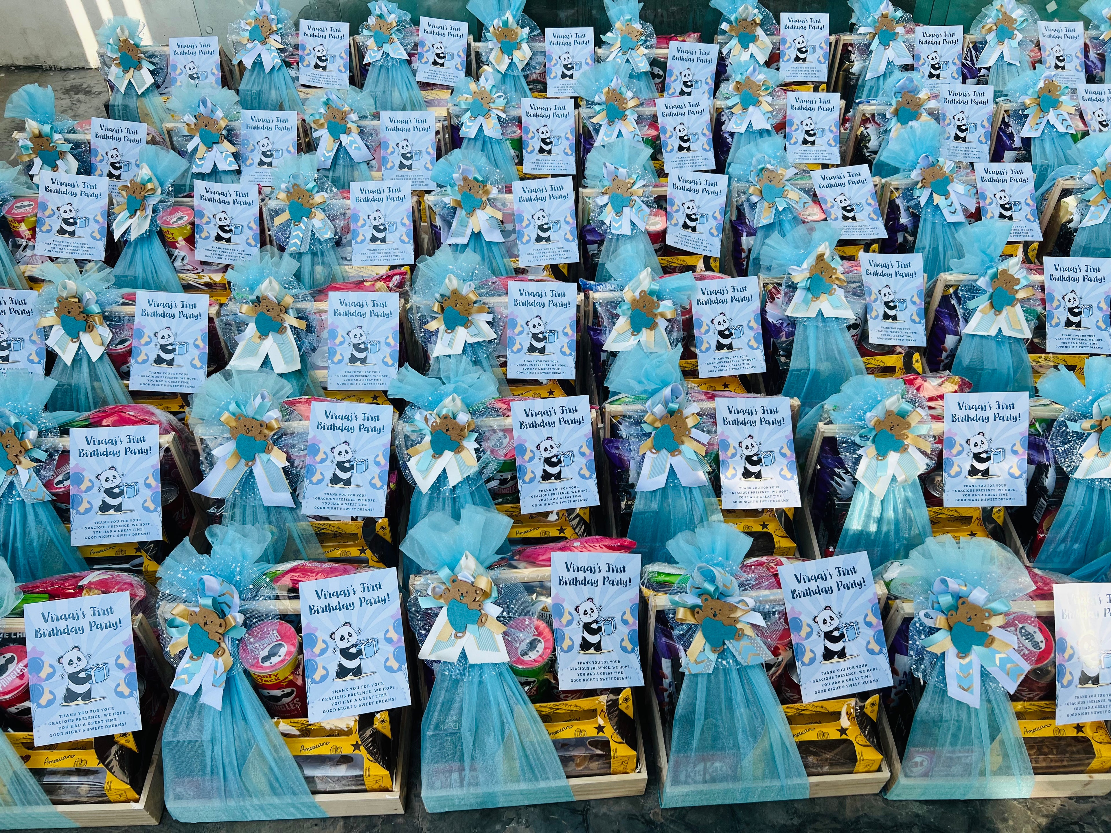 Display of blue gift baskets for birthday gift hamper with panda-themed decorations and labels.