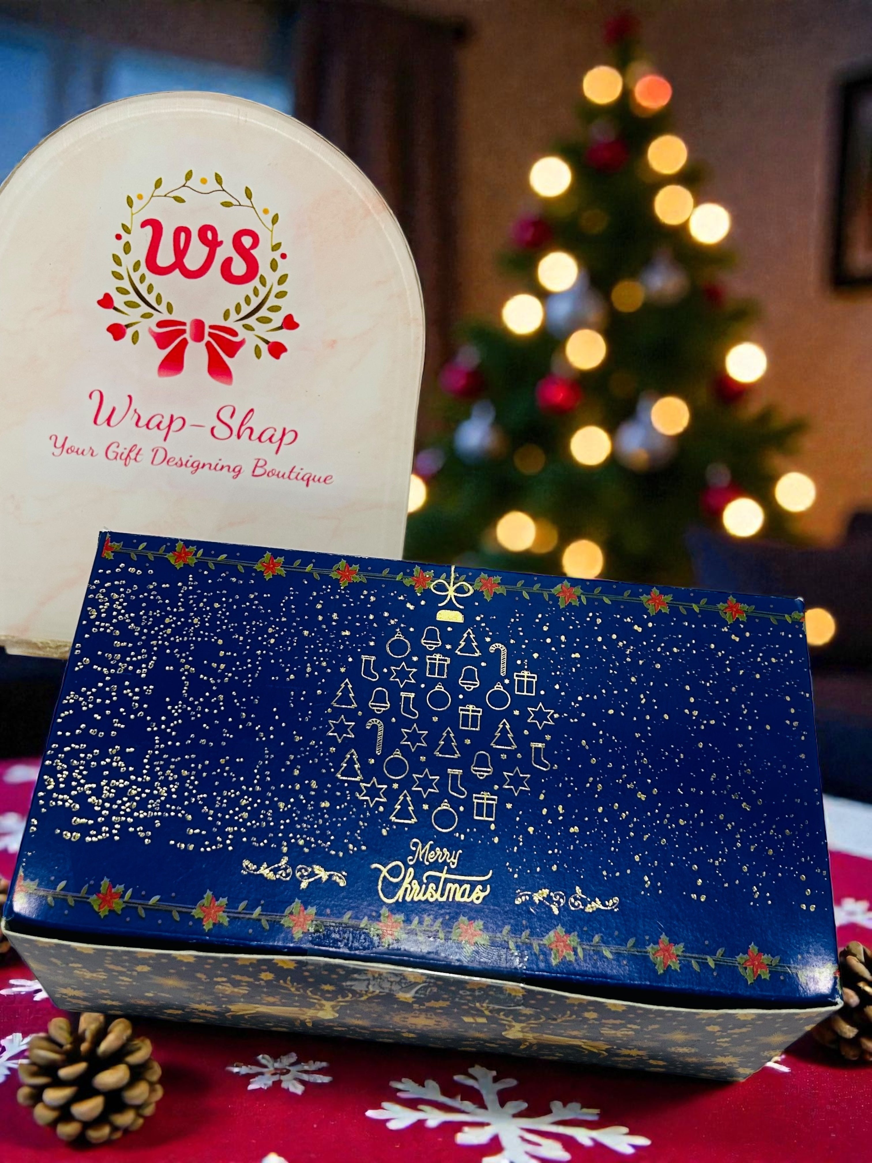 Christmas hamper in xmas themed gift box with chocolates and Santa tree hanging.