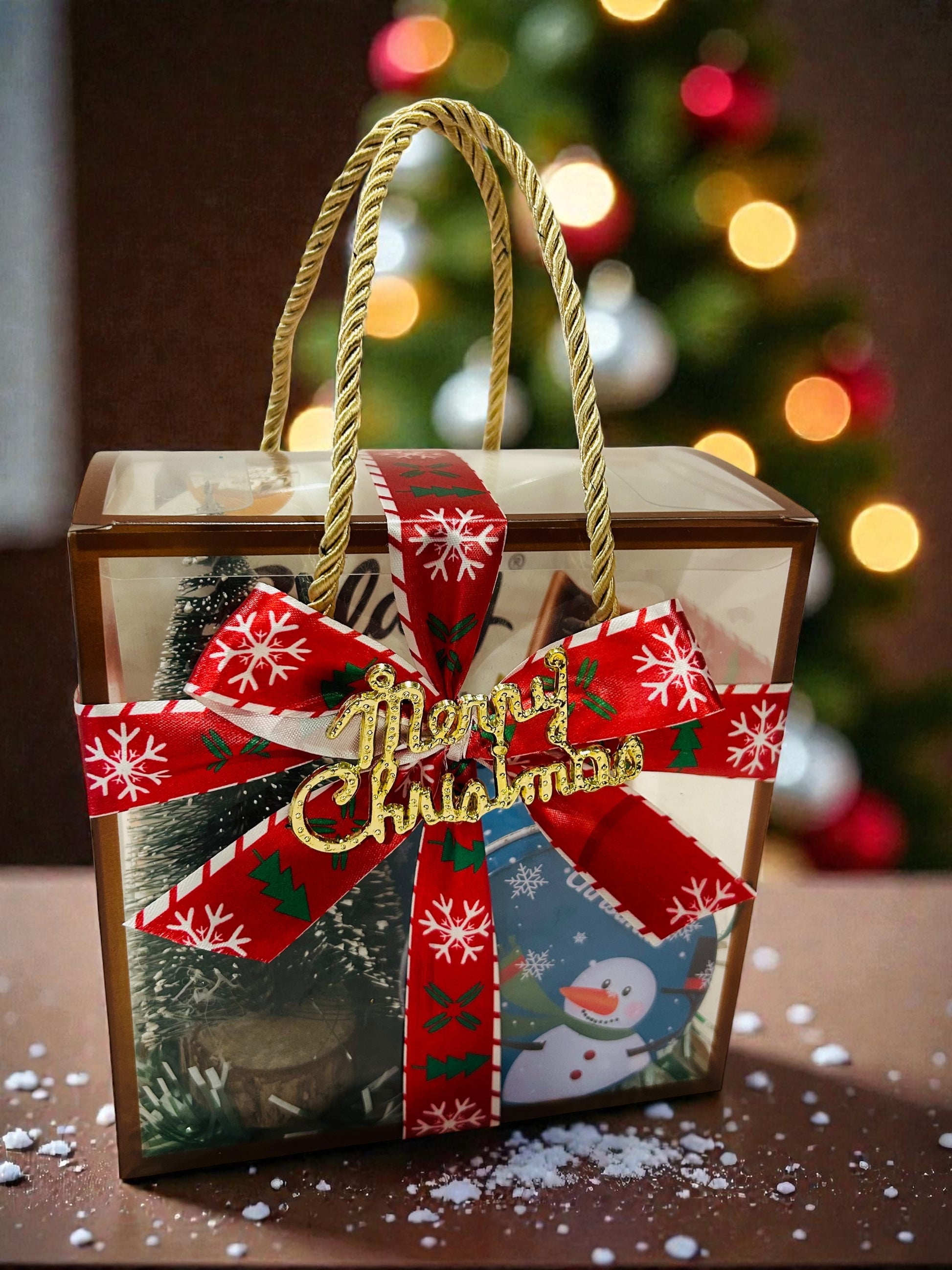 Christmas hamper in PVC bag with chocolate cupcake, table decorative tree and Galaxy chocolate.