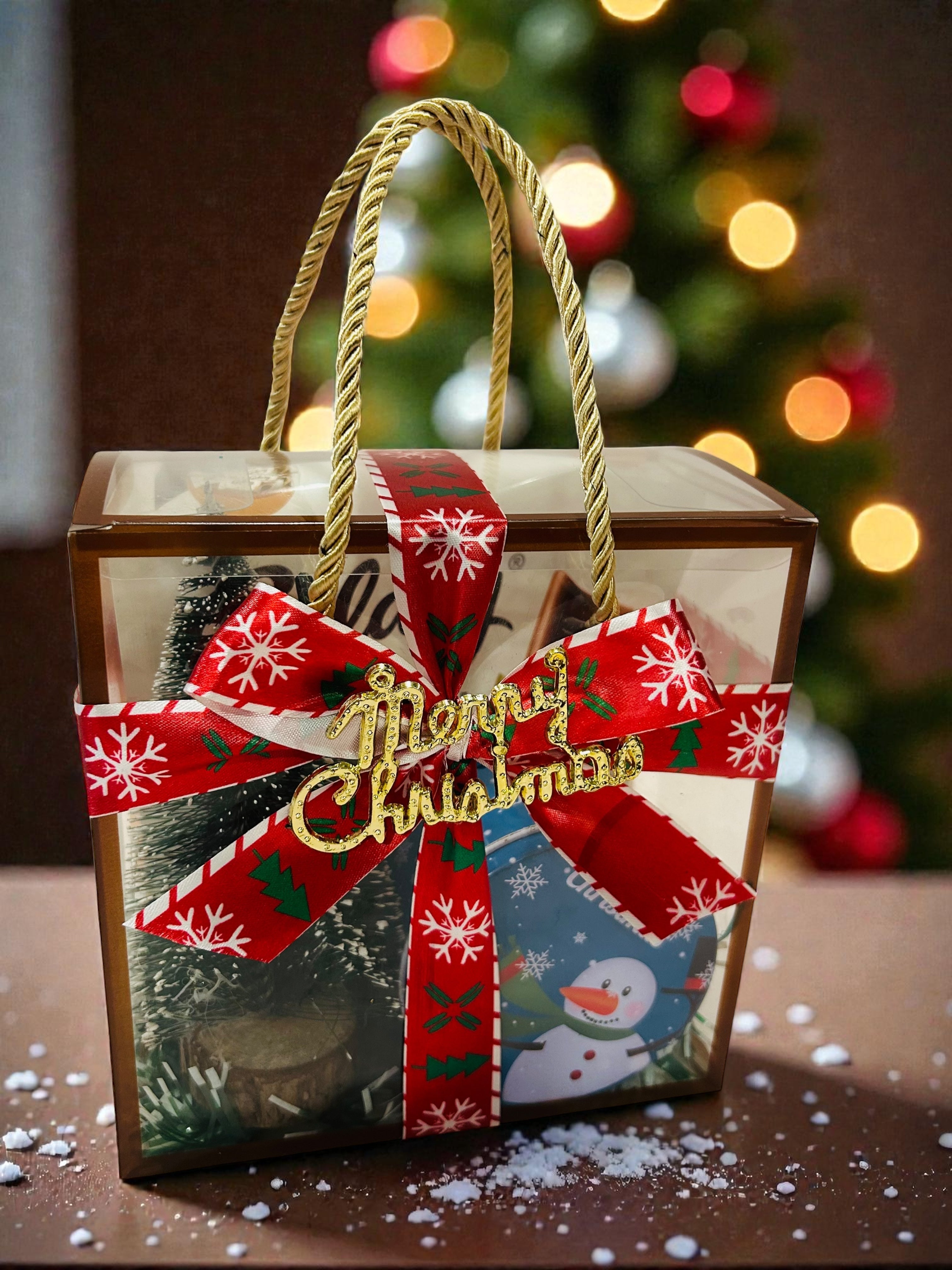 Christmas hamper in PVC bag with chocolate cupcake, table decorative tree and Galaxy chocolate.