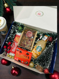 Christmas gift hamper with Starbucks coffee, plum cake, Lotus Biscoff and festive décor in gift box.