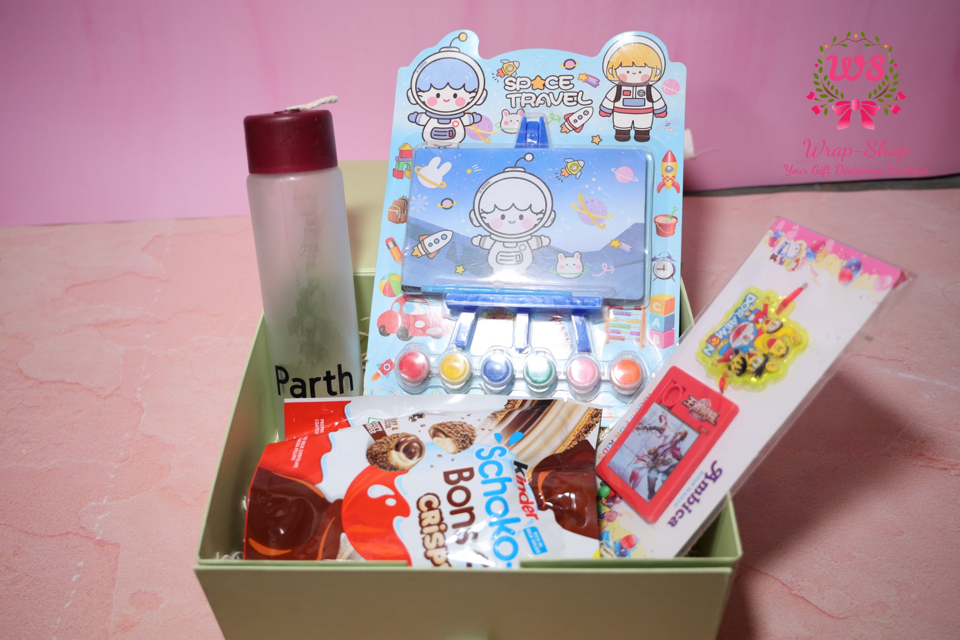 Wrap Shap Rakhi gift hamper for kids with painting kit, mini easel, personalized name glass bottle, kinderjoy Schoko Bons and rakhi in gift box