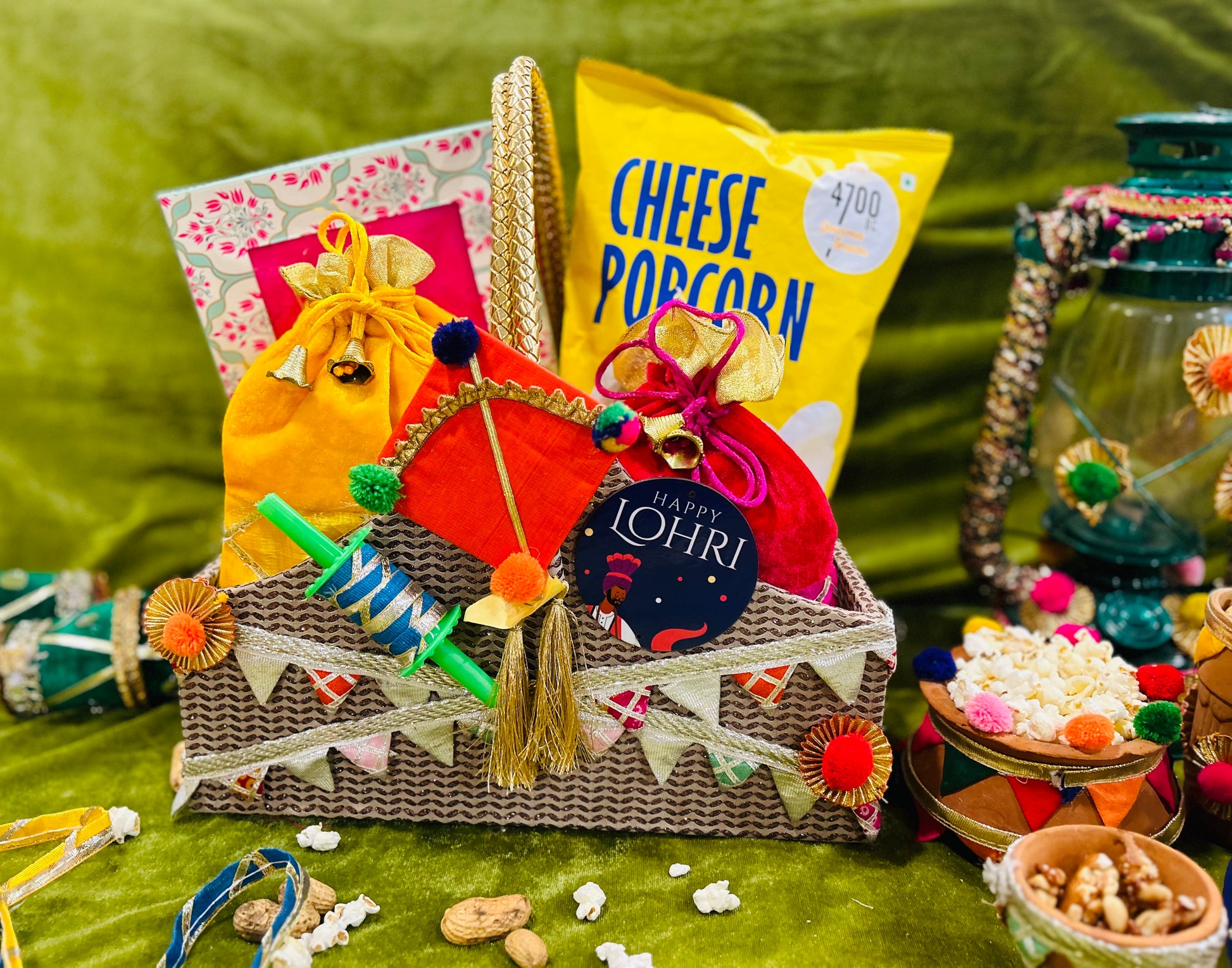 Lohri hamper with revdi, moongfali in potli, popcorn and til laddoo packed in a decorated basket.