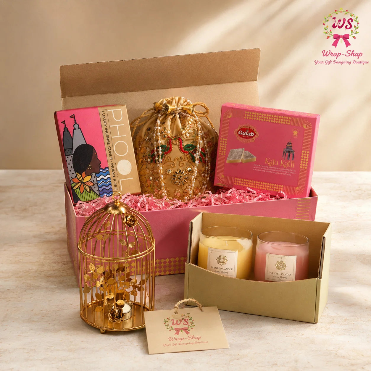 Shop the Luxury Candle Gift Hamper by Wrap Shap featuring two scented candles, a decorative bird cage tea-light holder, Kaju Katli, incense cones, a potli batwa bag, and premium gift box packaging. Perfect for Diwali, birthdays, housewarming, weddings, corporate gifting, and festive celebrations.