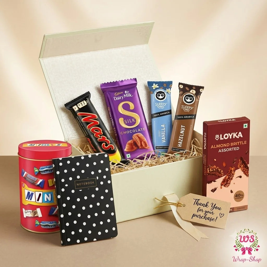 Luxury Chocolate Gift Hamper by Wrap Shap featuring Minis, Dairy Milk Chocolate, Mars Chocolate Bar, Loyka Almond Brittle, Sleepy Owl Coffee sachets, premium notebook, thank-you tag, and an elegant ribbon-tied gift box for birthdays, festivals, corporate gifting, and special occasions.