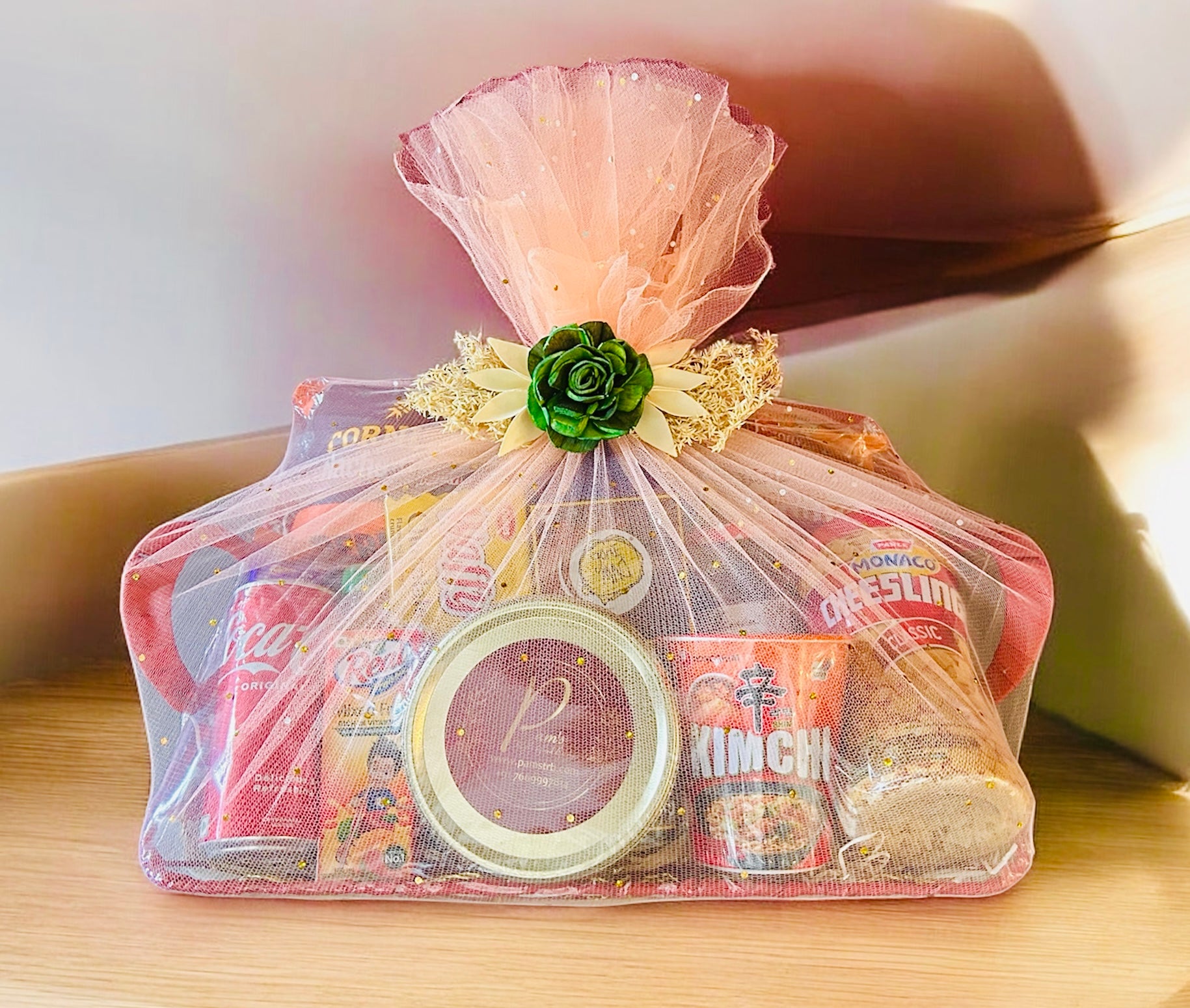 A medium rectangular decorated gift basket filled with premium gourmet treats, including nachos, chocolates, bakery nankhatai, peanuts, juice, coke, and imported marmalade, making it the perfect luxury gift for birthdays, festivals, and corporate celebrations.
