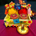 Premium Lohri gift hamper in pine basket with velvet potlis, til laddoo and gur revdi jars.