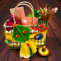 Premium Lohri gift hamper in decorated rafia basket with peanut chikki, gajaks, popcorn and moongfali.