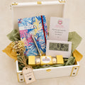 Premium student achievement gift hamper with designer notebook, metal pen, digital table clock, Ferrero Rocher chocolates and custom message card in a wooden trunk by Wrap Shap.