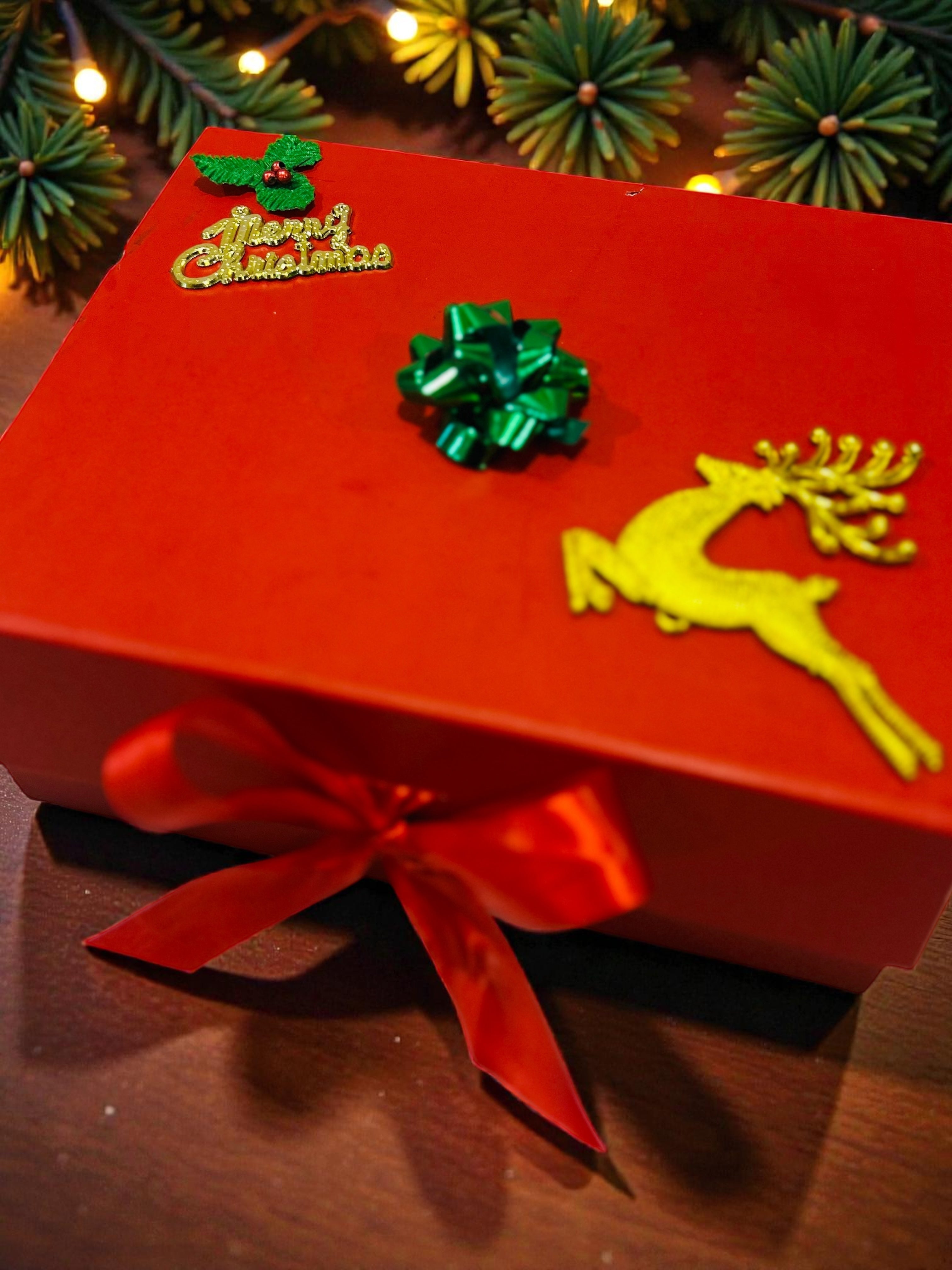 Christmas hamper featuring Christmas-themed mug, candle, cookies and chocolates in red gift box.