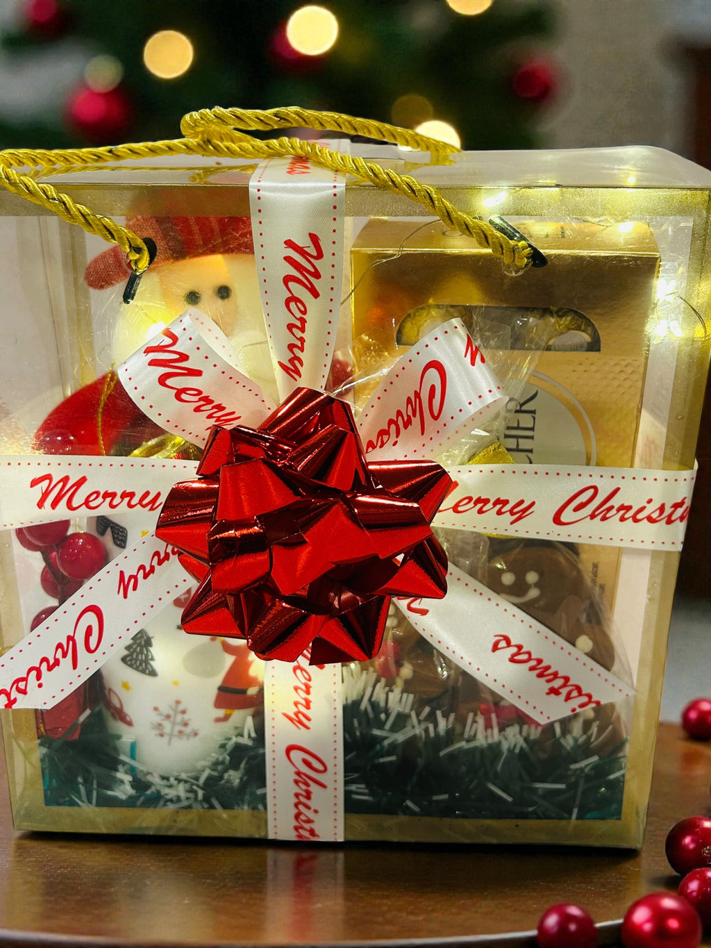 Secret Santa Christmas gift hamper with Ferrero Rocher, xmas mug and festive décor in transparent bag.