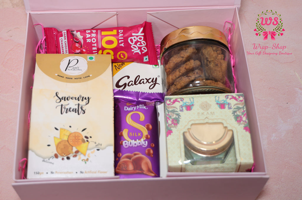 Wrap Shap gift hamper with savoury snacks, Galaxy and Dairy Milk chocolates, cookies in jar, scented candle and protein bar in a reusable rigid box
