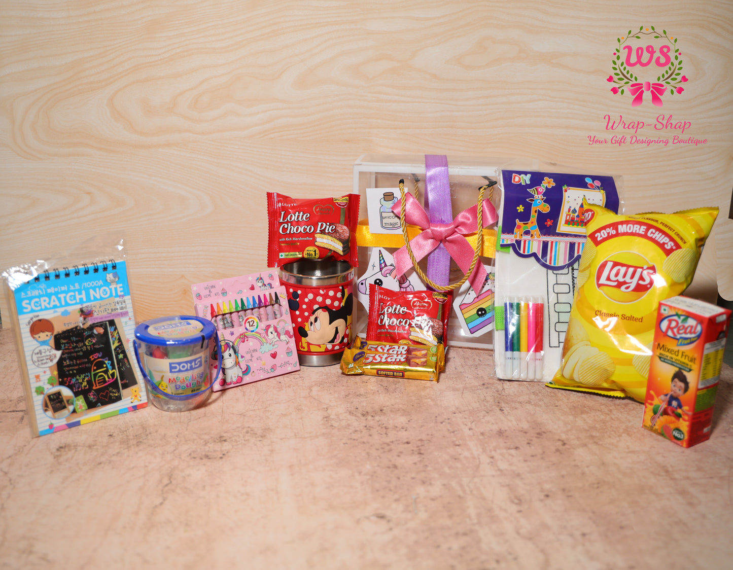 Wrap Shap unicorn-themed gift hamper for girls with scratch notepad, dough, crayons, tumbler, DIY bag, chocolates and snacks in PVC carry bag
