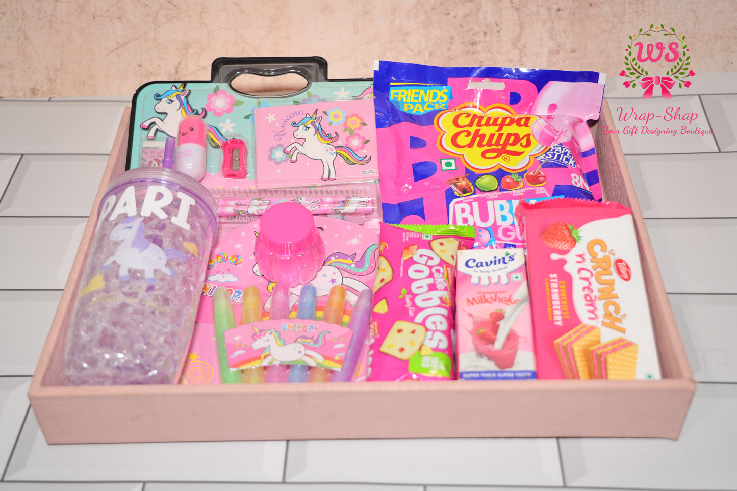 Wrap Shap unicorn theme gift hamper for girls with personalized tumbler, stationery kit, glitter pens, slime, chupa chups, cake and snacks in gifting tray
