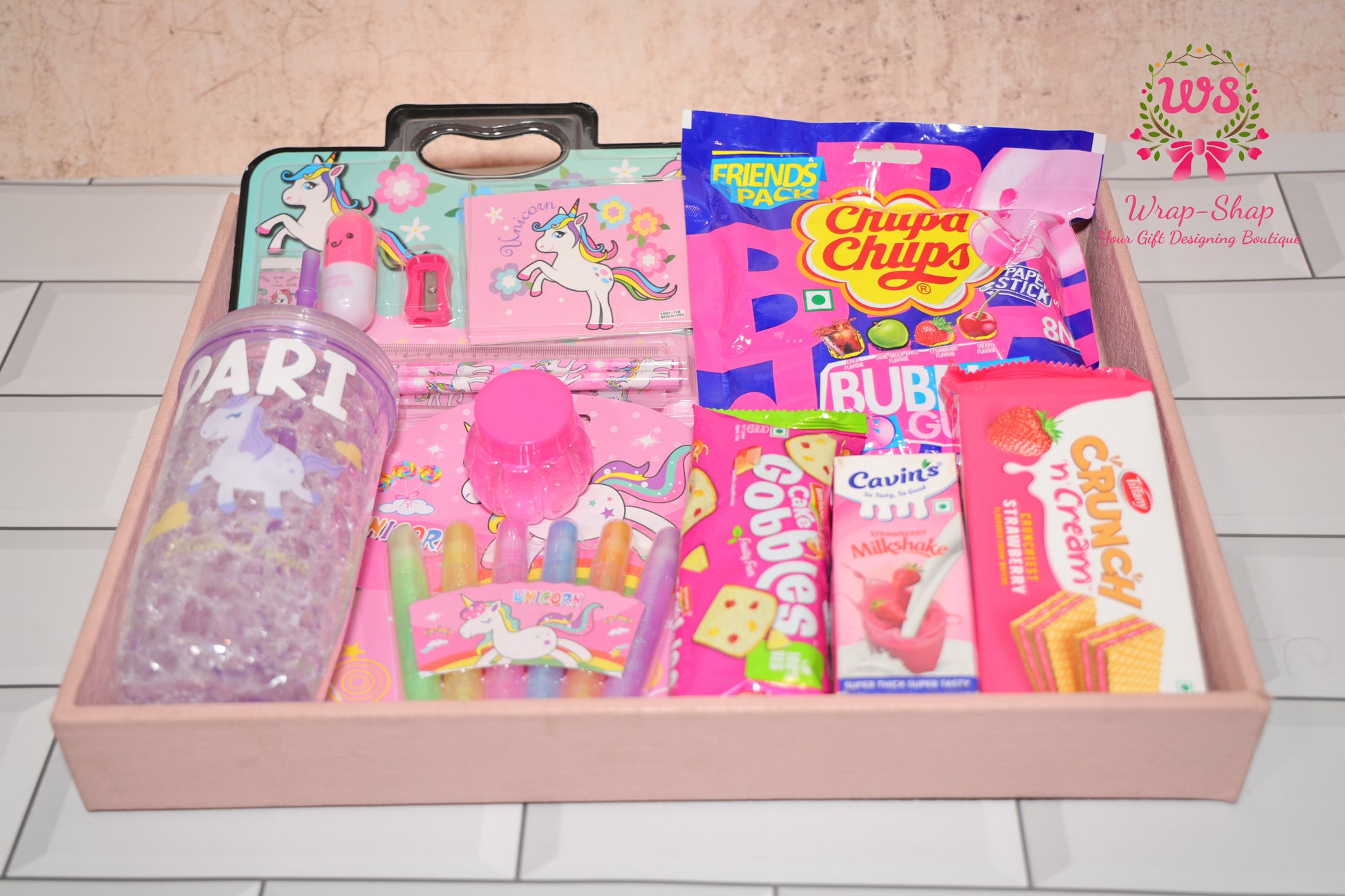 Wrap Shap unicorn theme gift hamper for girls with personalized tumbler, stationery kit, glitter pens, slime, chupa chups, cake and snacks in gifting tray